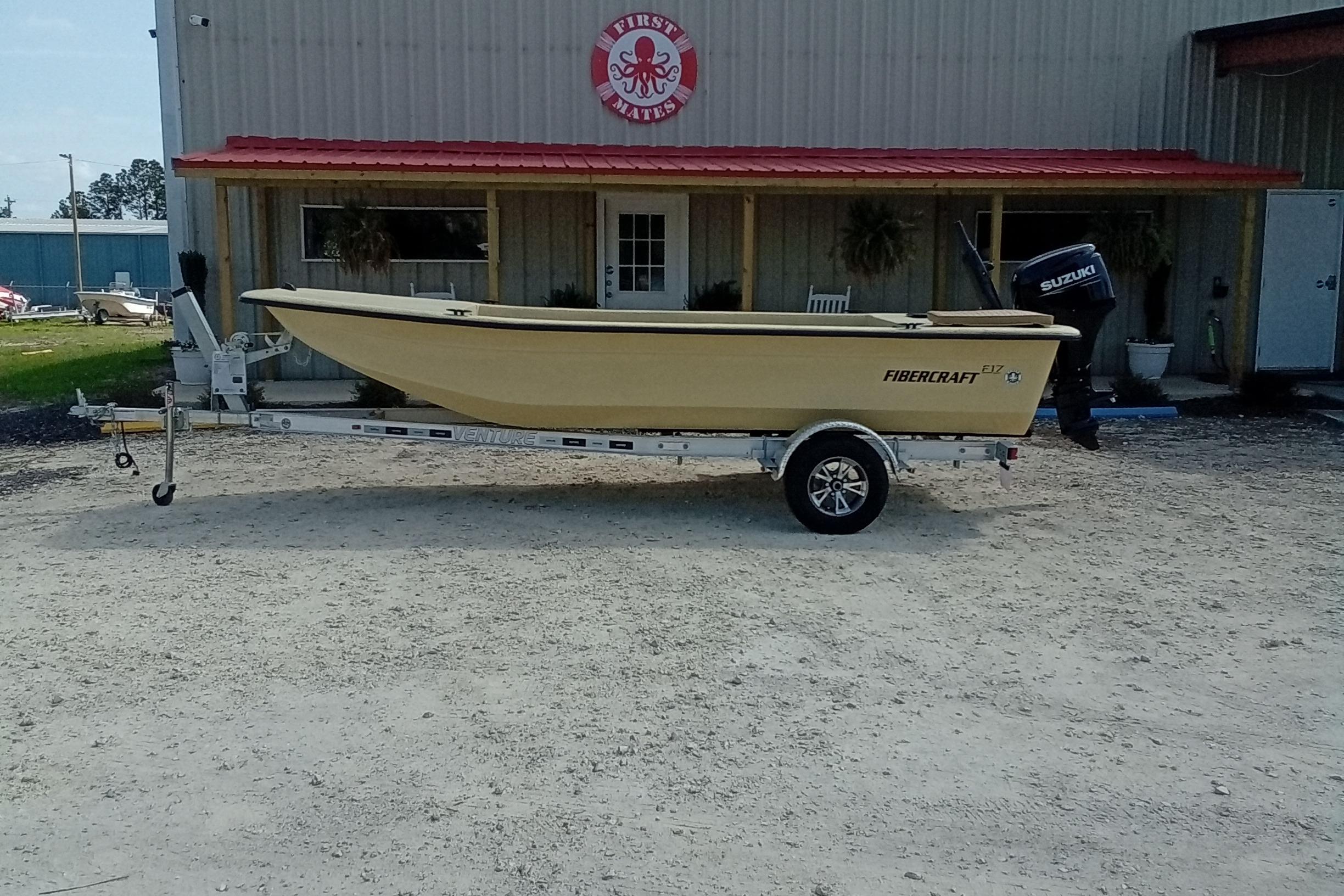 2025 Fibercraft F17 boat on trailer outside a building with red roof.
