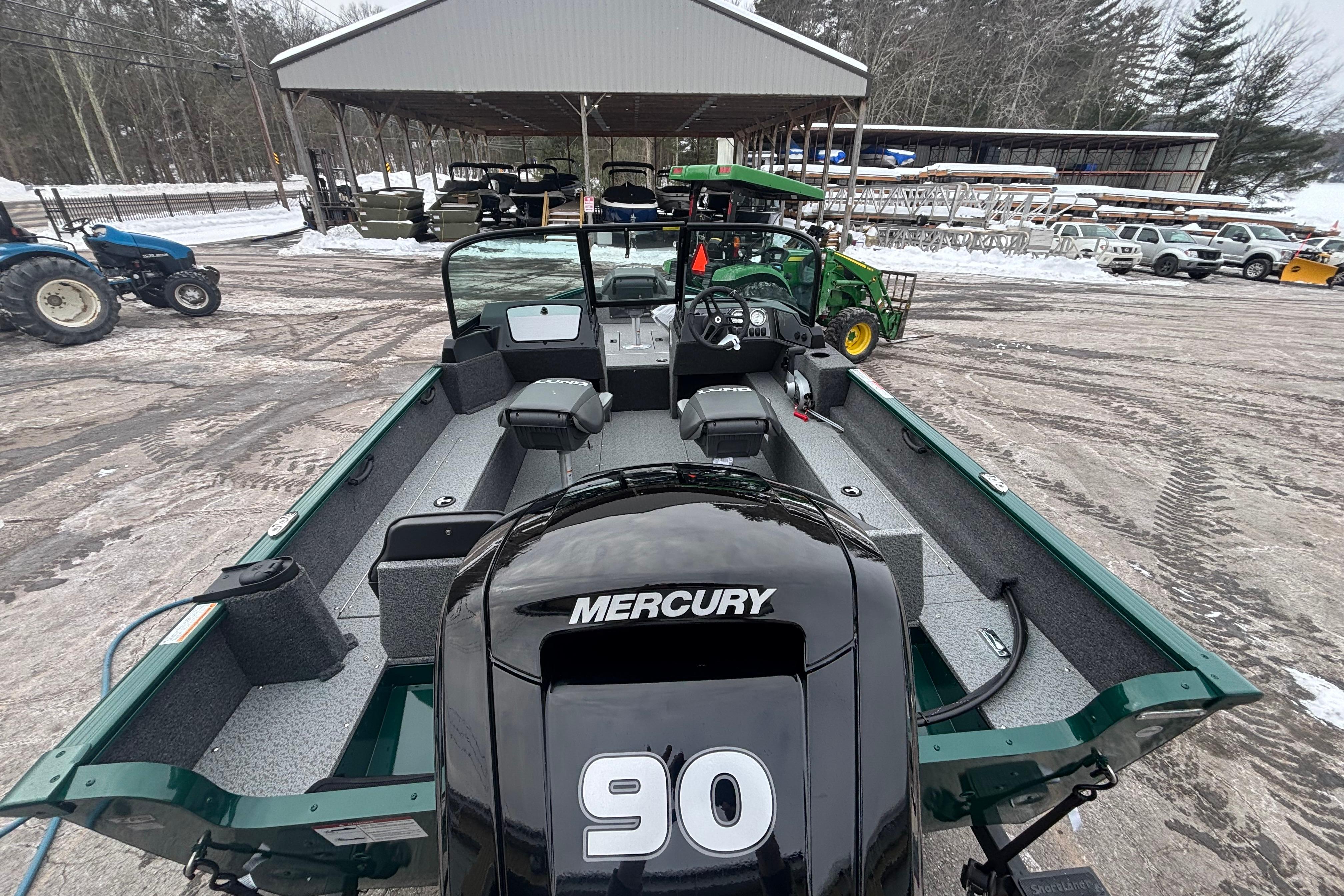 2026 Lund 1650 Rebel XL Sport boat with Mercury 90 engine, parked outdoors in snowy setting.