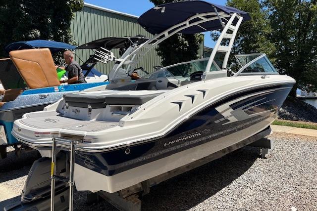 2023 Chaparral 21 SSi boat with sleek design and blue accents, displayed outdoors.