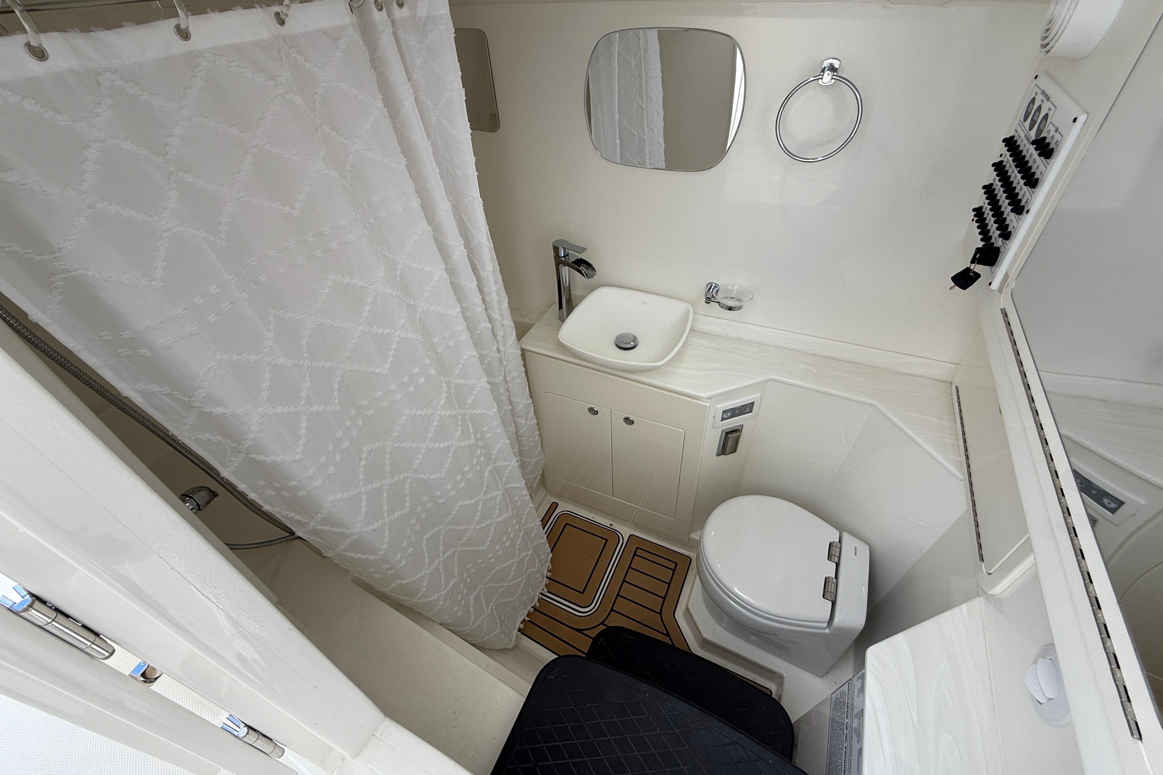 Bathroom interior of 2026 World Cat 400 DC-X Island boat, featuring shower, sink, and toilet.