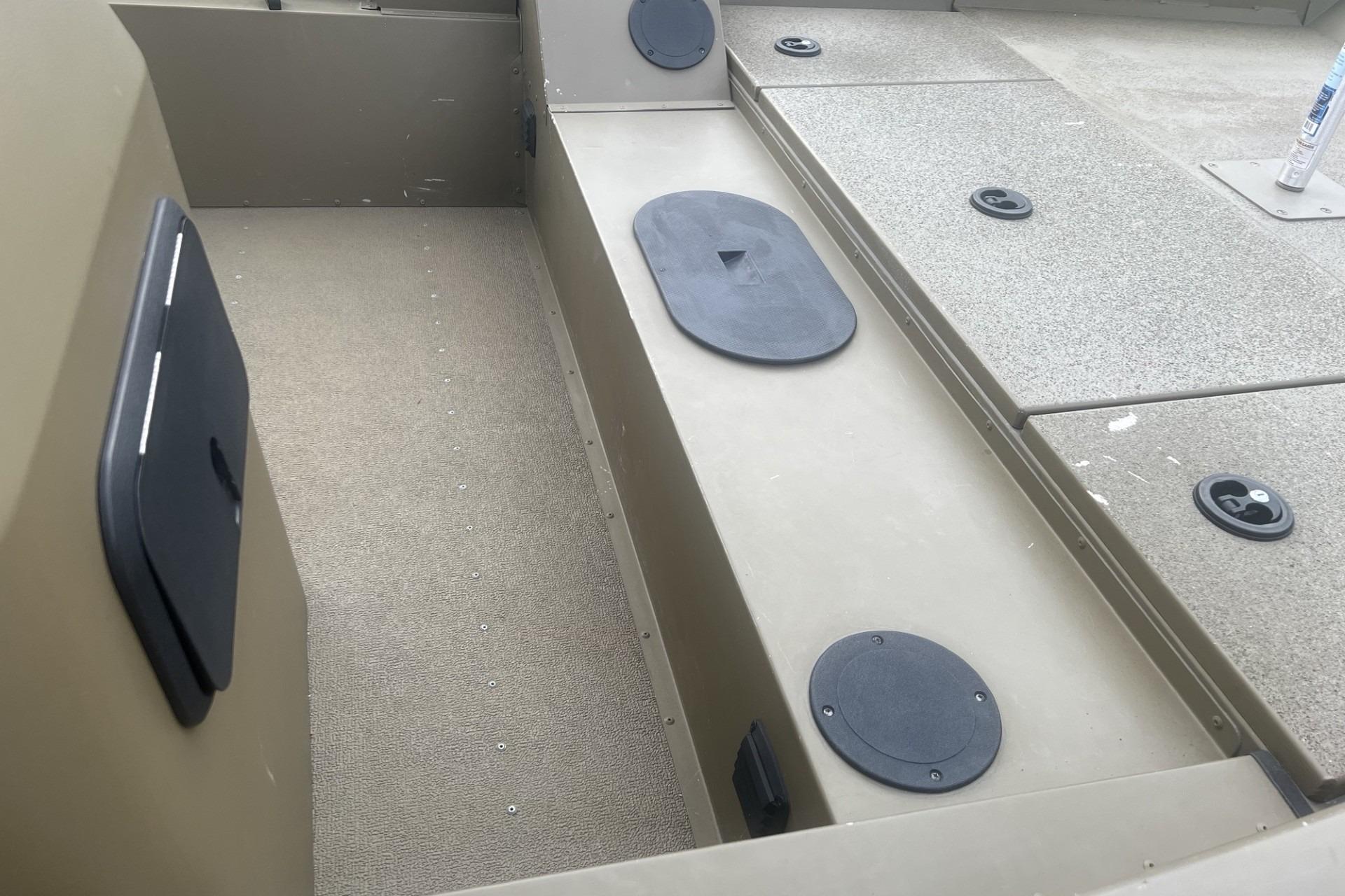 Interior view of a 2016 G3 1756 SC boat, featuring storage compartments and seating area.