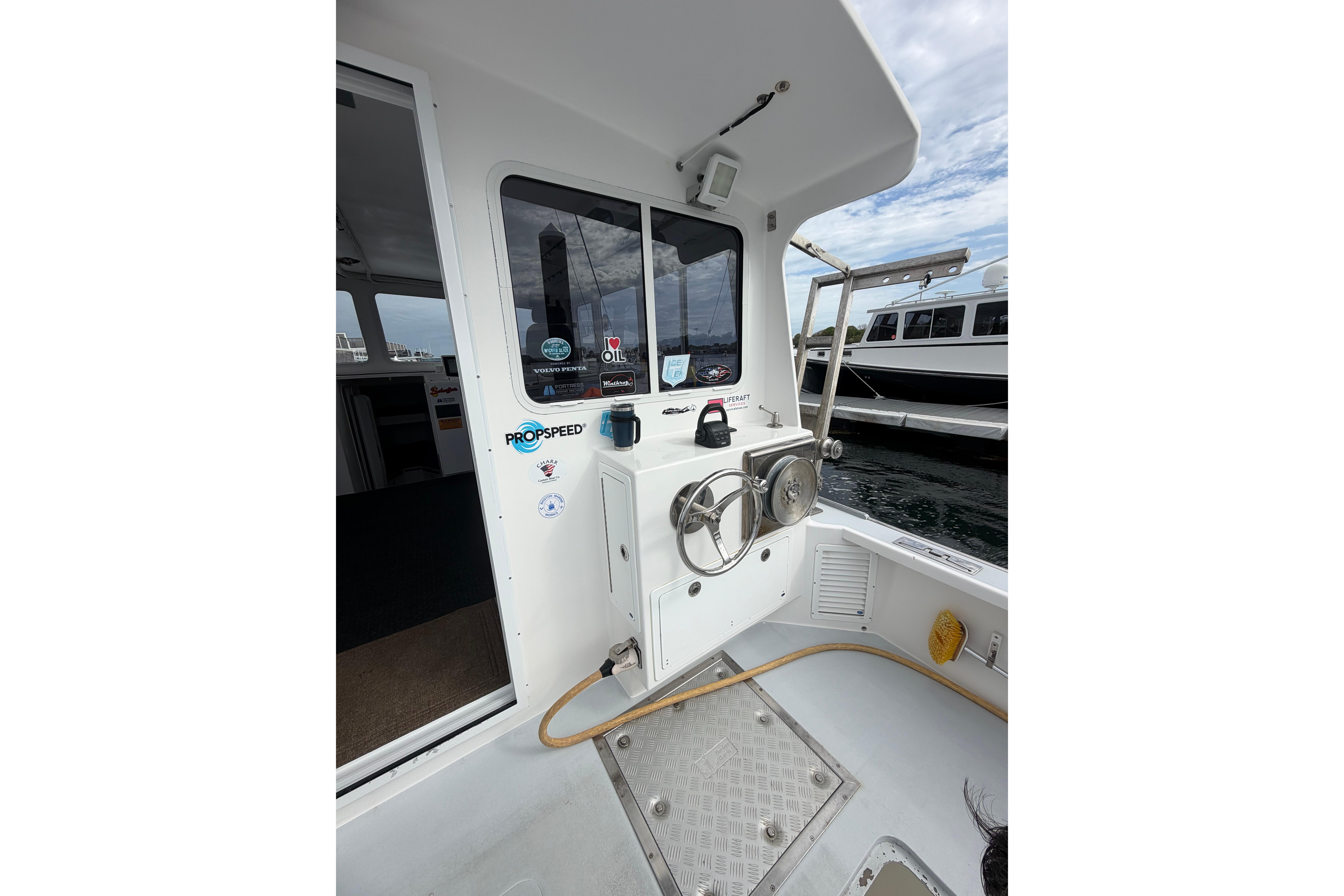 2018 H&H Marine Osmond Beal boat deck with steering wheel and dock view.