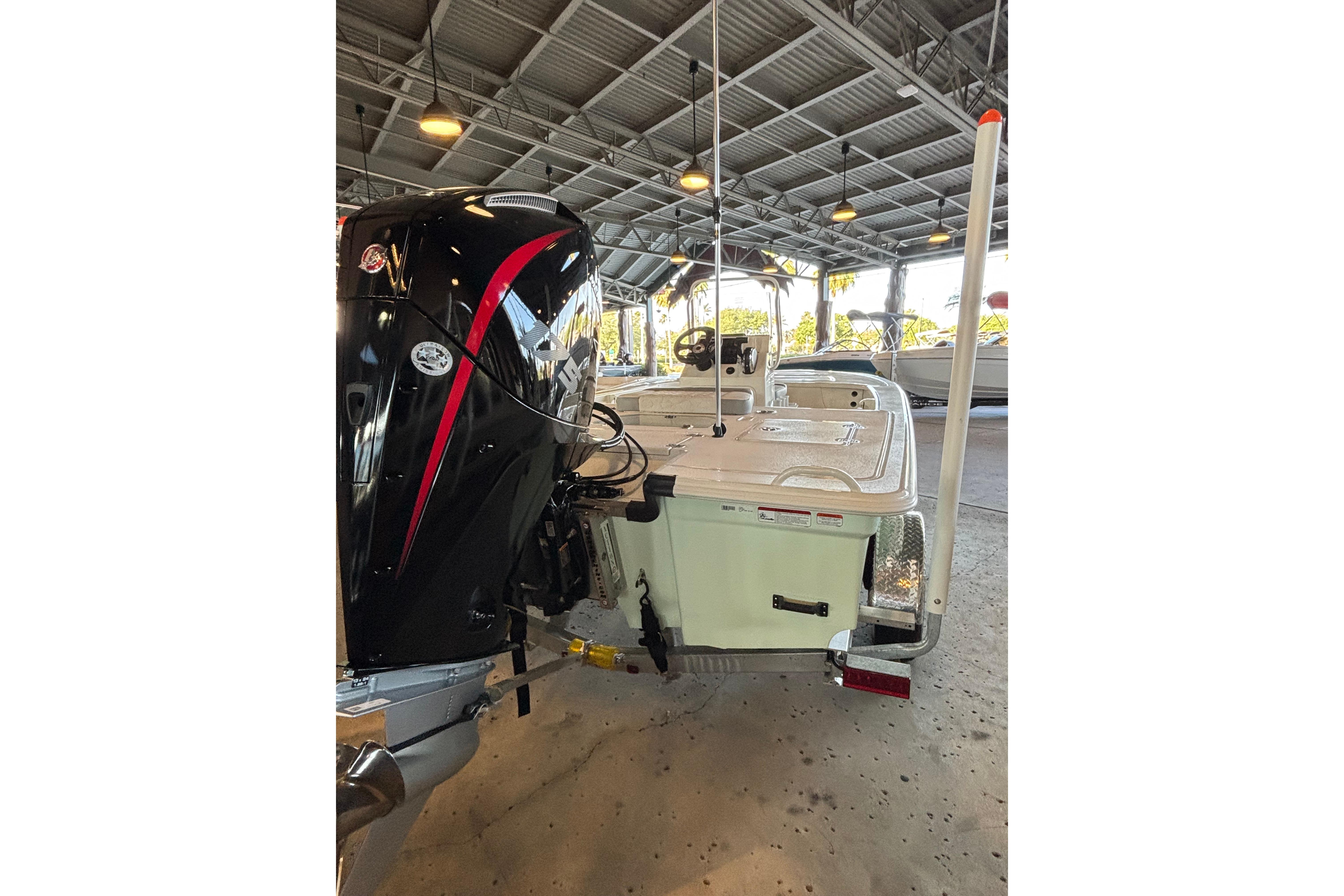 2026 Mako 18 Pro Skiff boat with powerful outboard motor in covered storage.