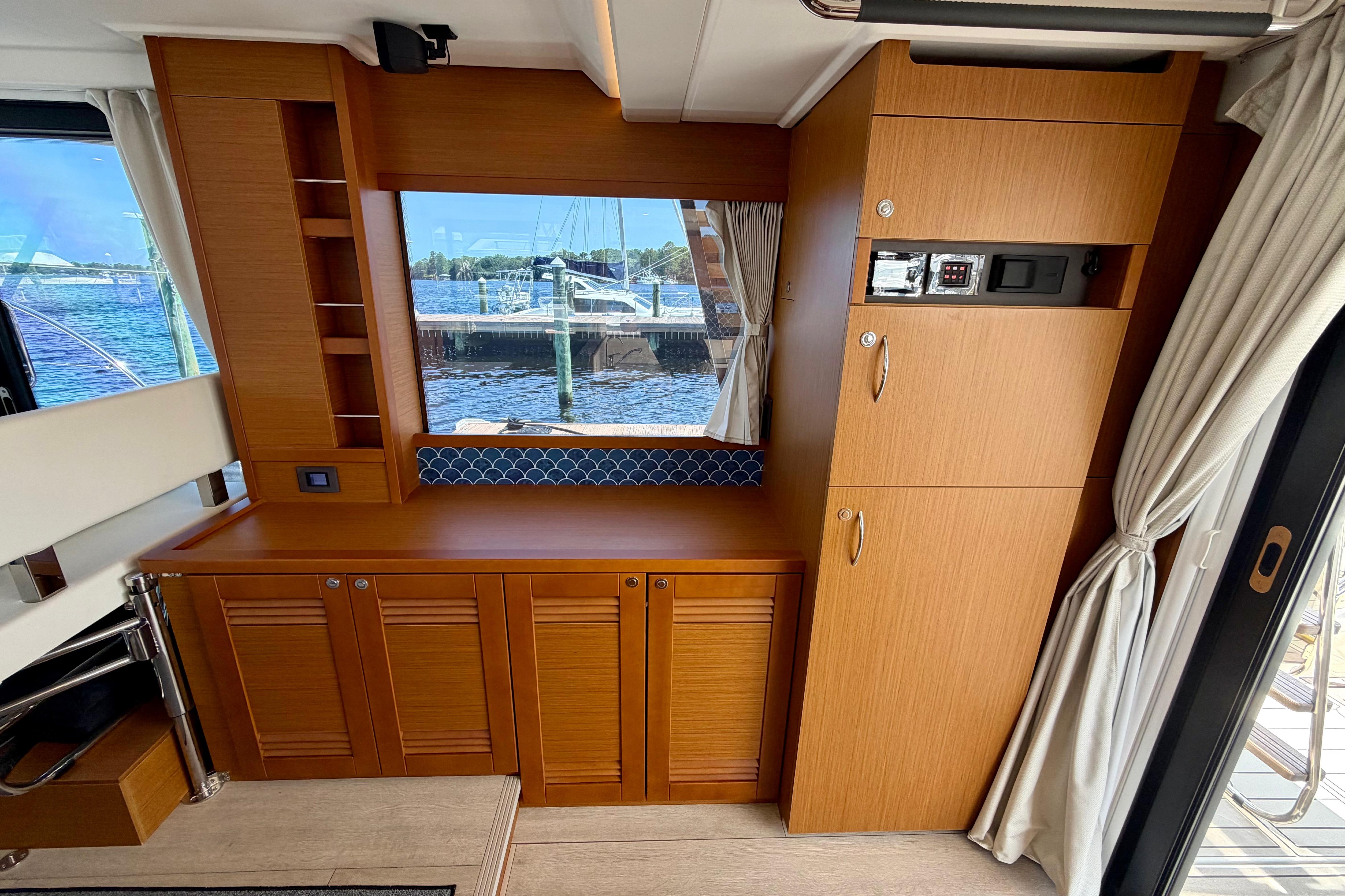 Interior of 2025 Beneteau Swift Trawler 41 Fly with wood cabinetry and window view.