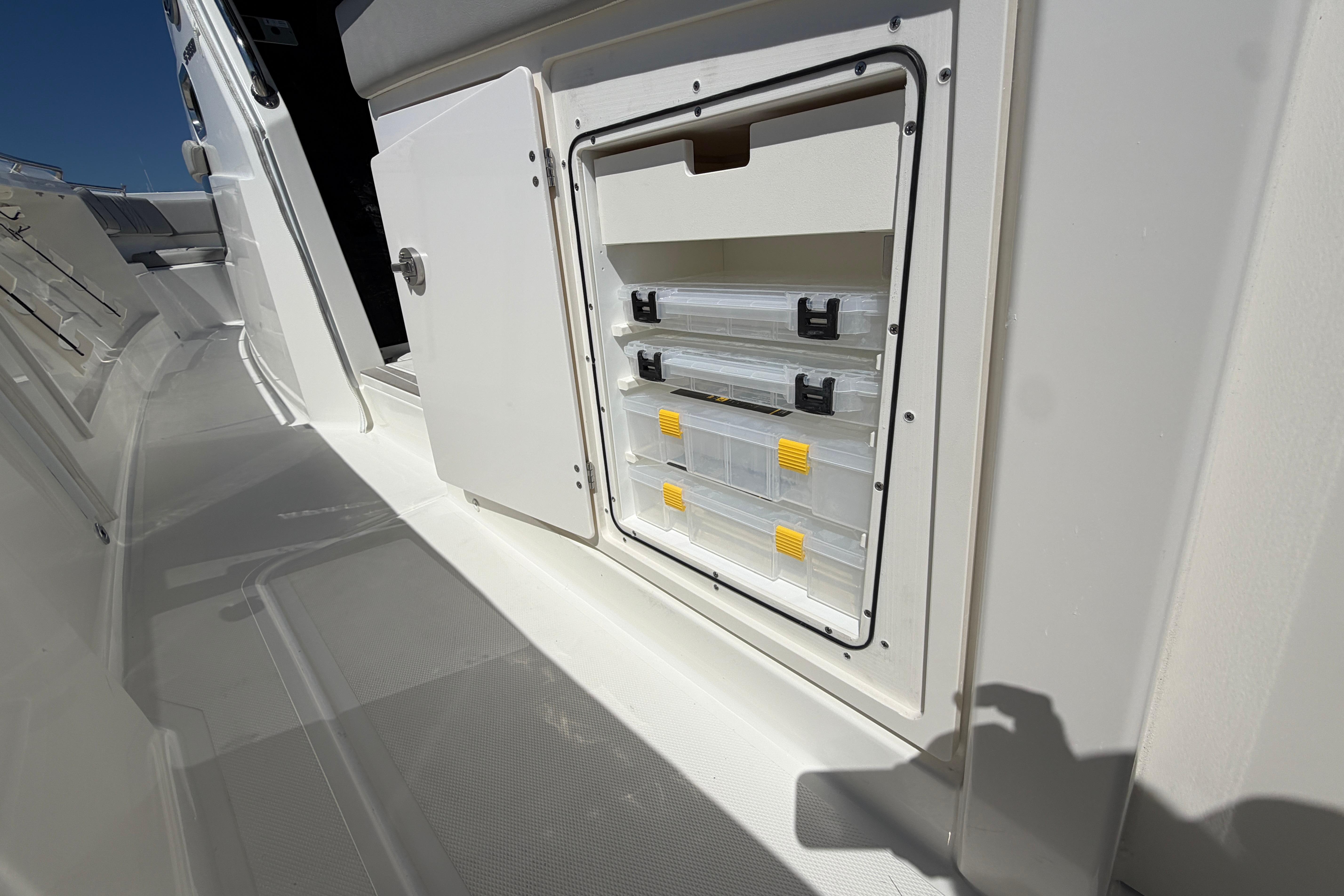 Storage compartment on 2026 Pursuit S 358 Sport boat, featuring organized tackle boxes.