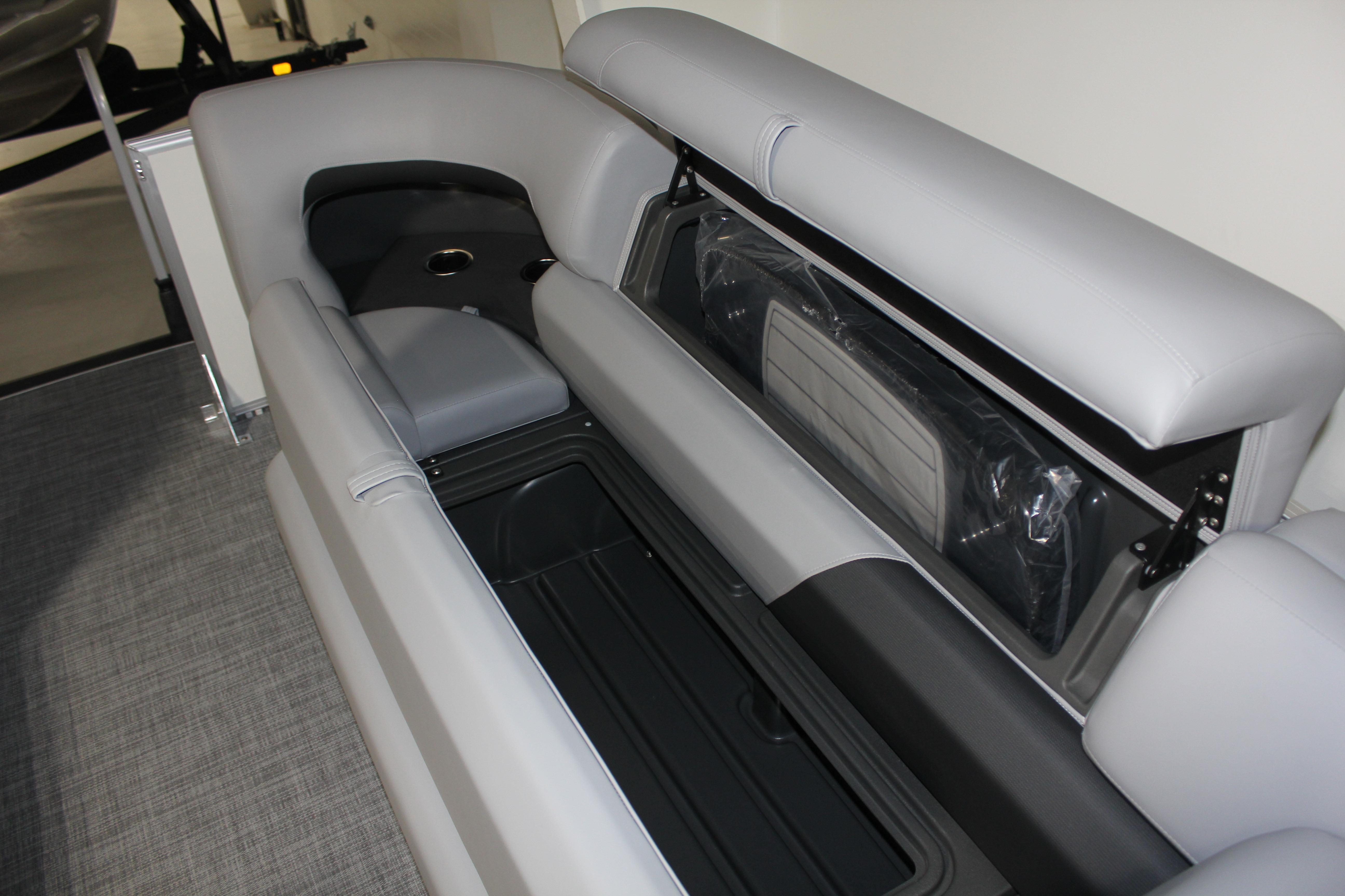 2026 Sun Tracker Party Barge 22 DLX interior with gray seating and storage compartments.