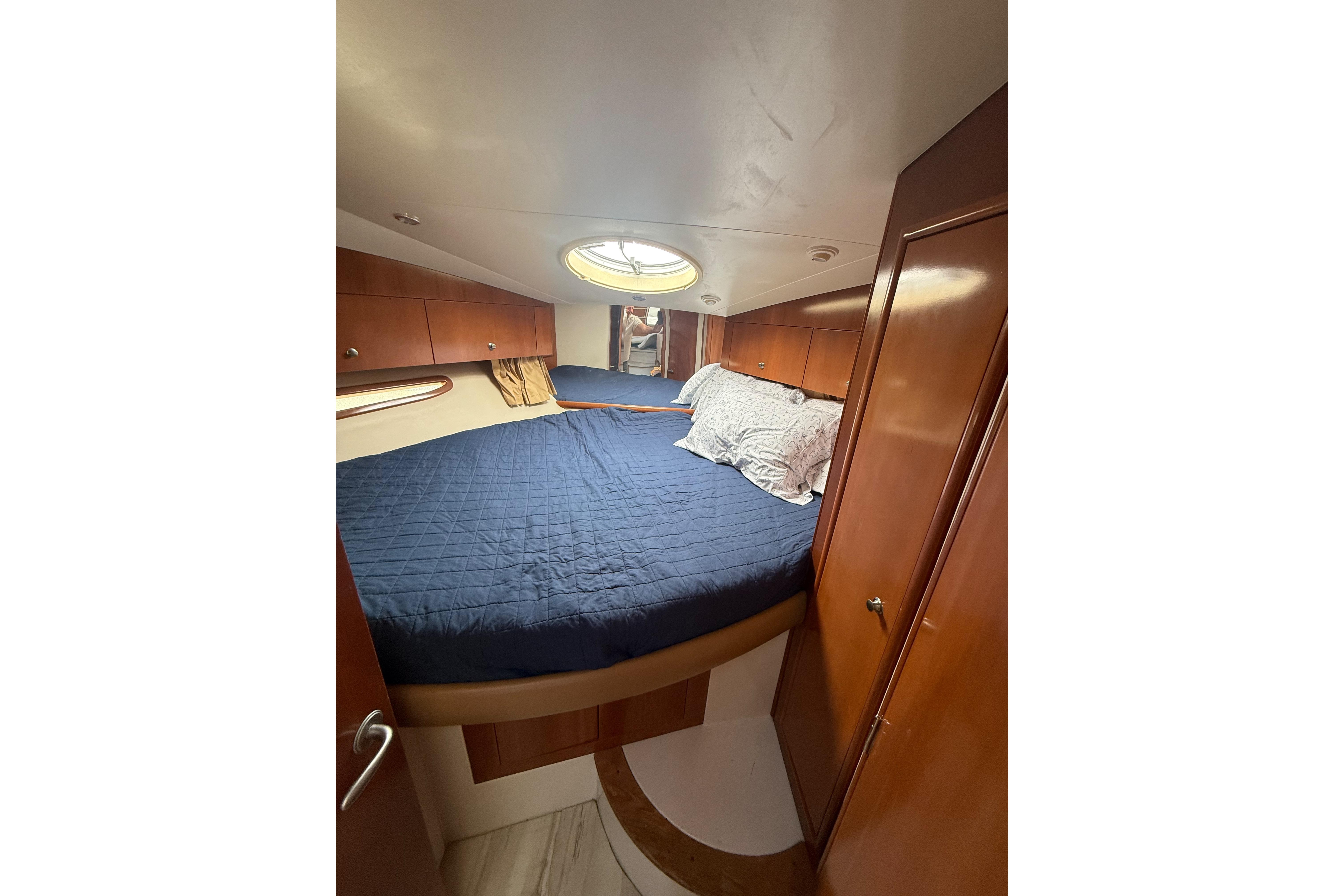 Interior cabin of 2006 Carver 43 Motor Yacht with cozy bed and wooden cabinetry.