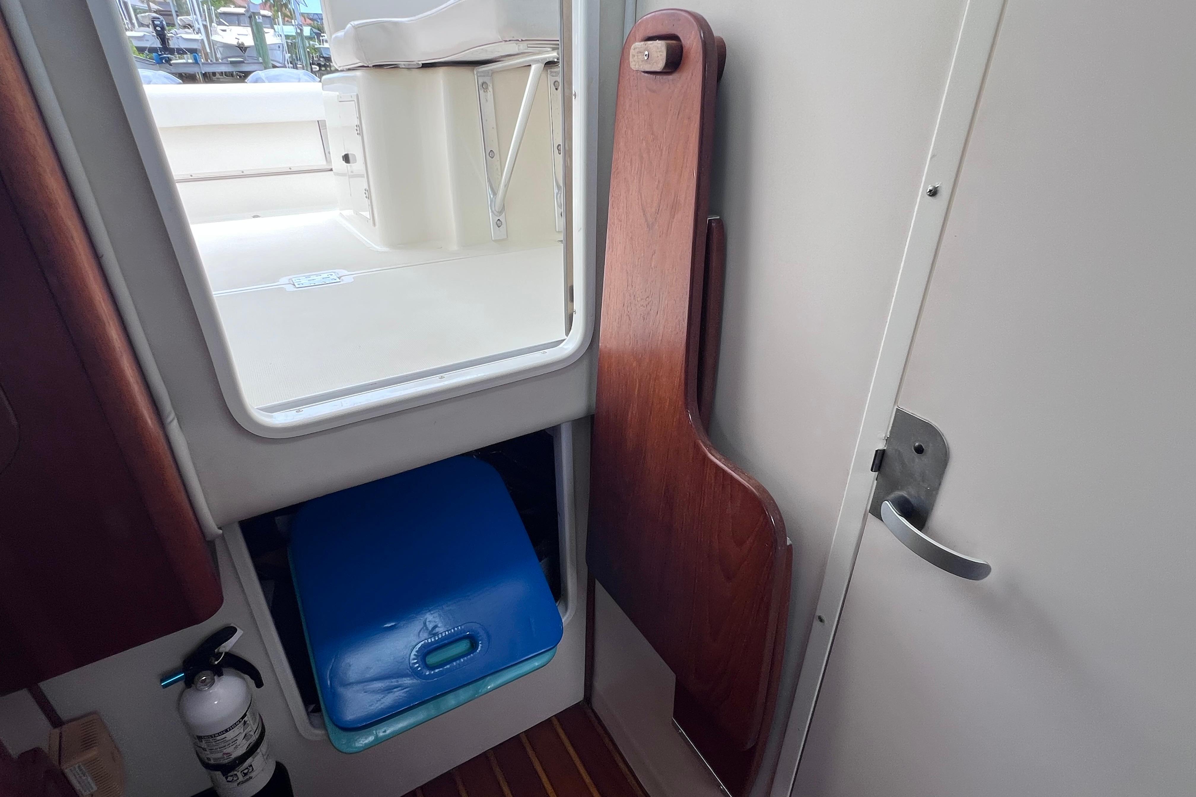 Interior view of a 2005 Pursuit 3070 Offshore boat, featuring a wooden panel and storage area.