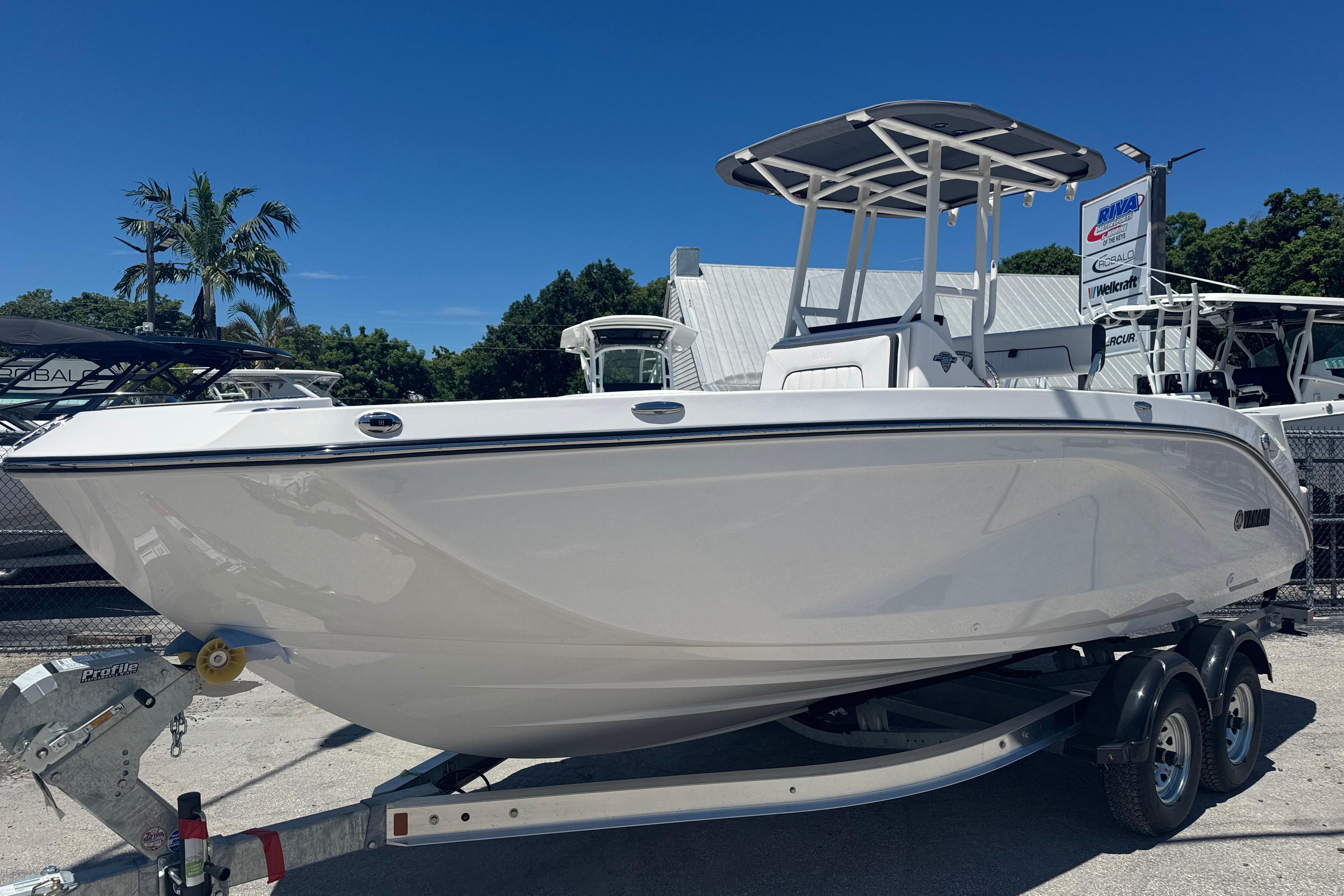 2026 Yamaha Boats 220 FSH Sport on trailer, displayed outdoors under clear blue sky.