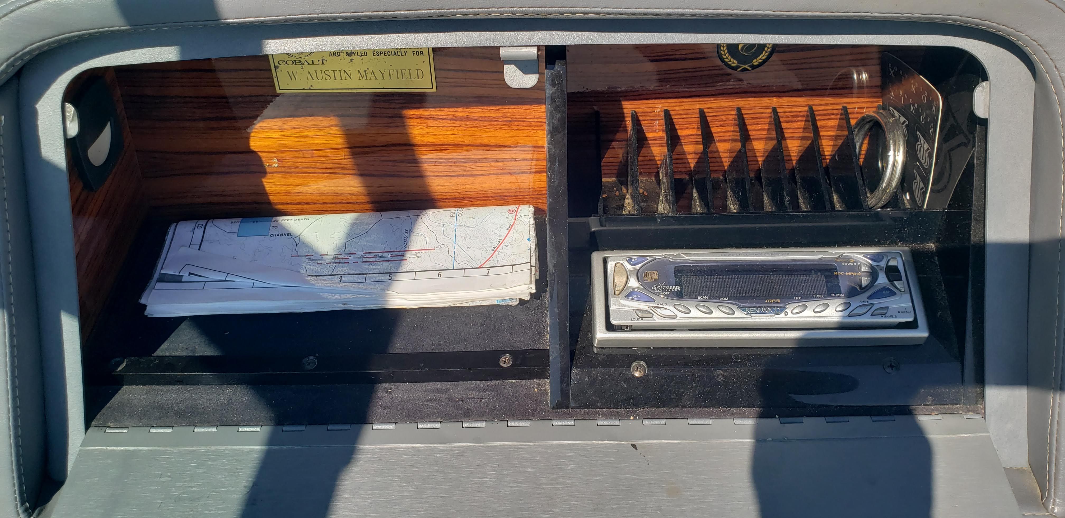 Dashboard of a 1993 Cobalt 272 with maps and radio.