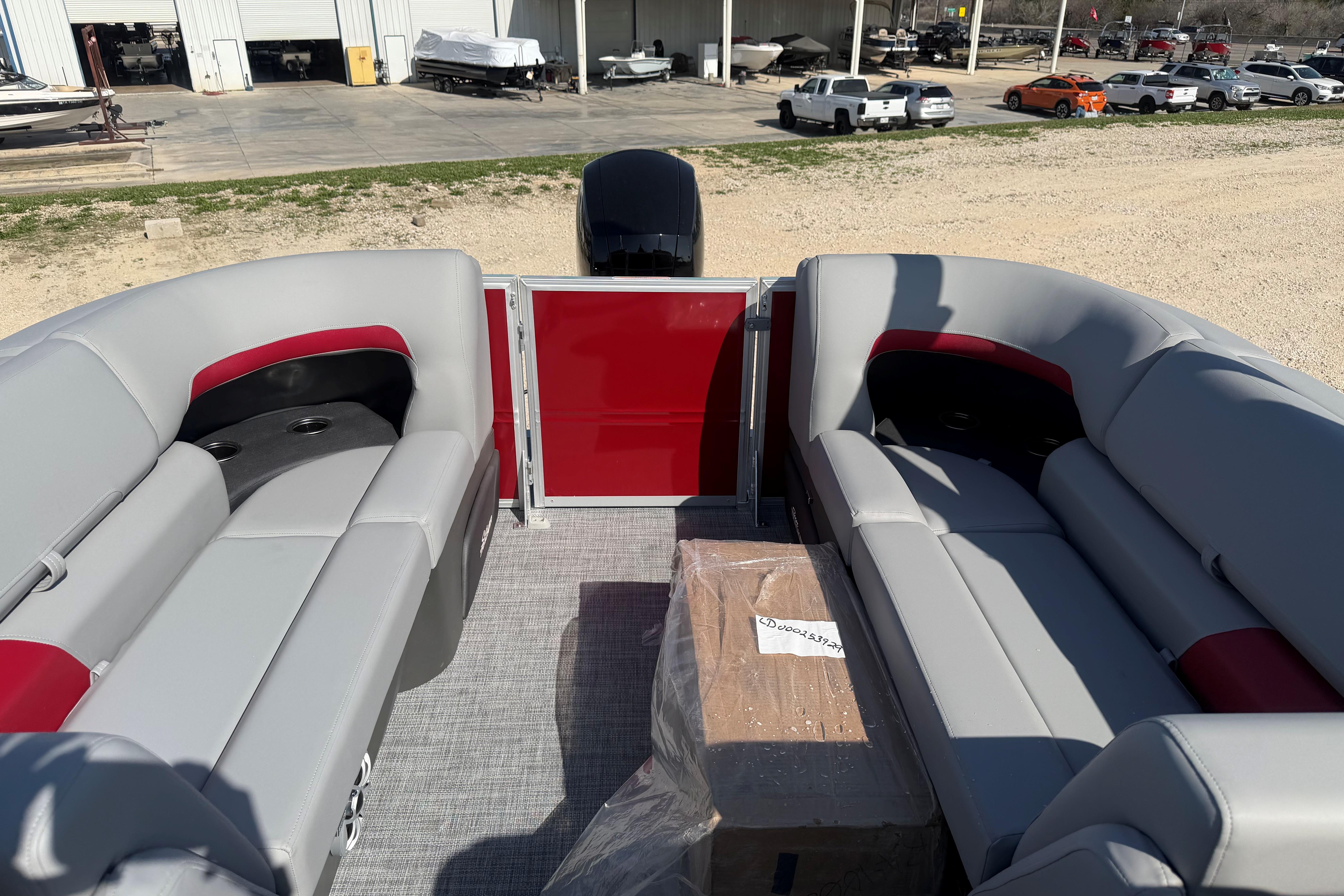 2026 Sun Tracker Party Barge 22 DLX interior with gray and red seating.