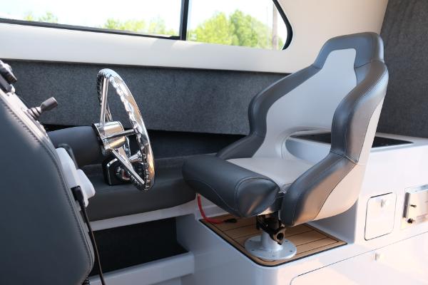Makaira Gen3 800 boat interior, featuring a modern captain's chair and steering wheel, 2023 model.