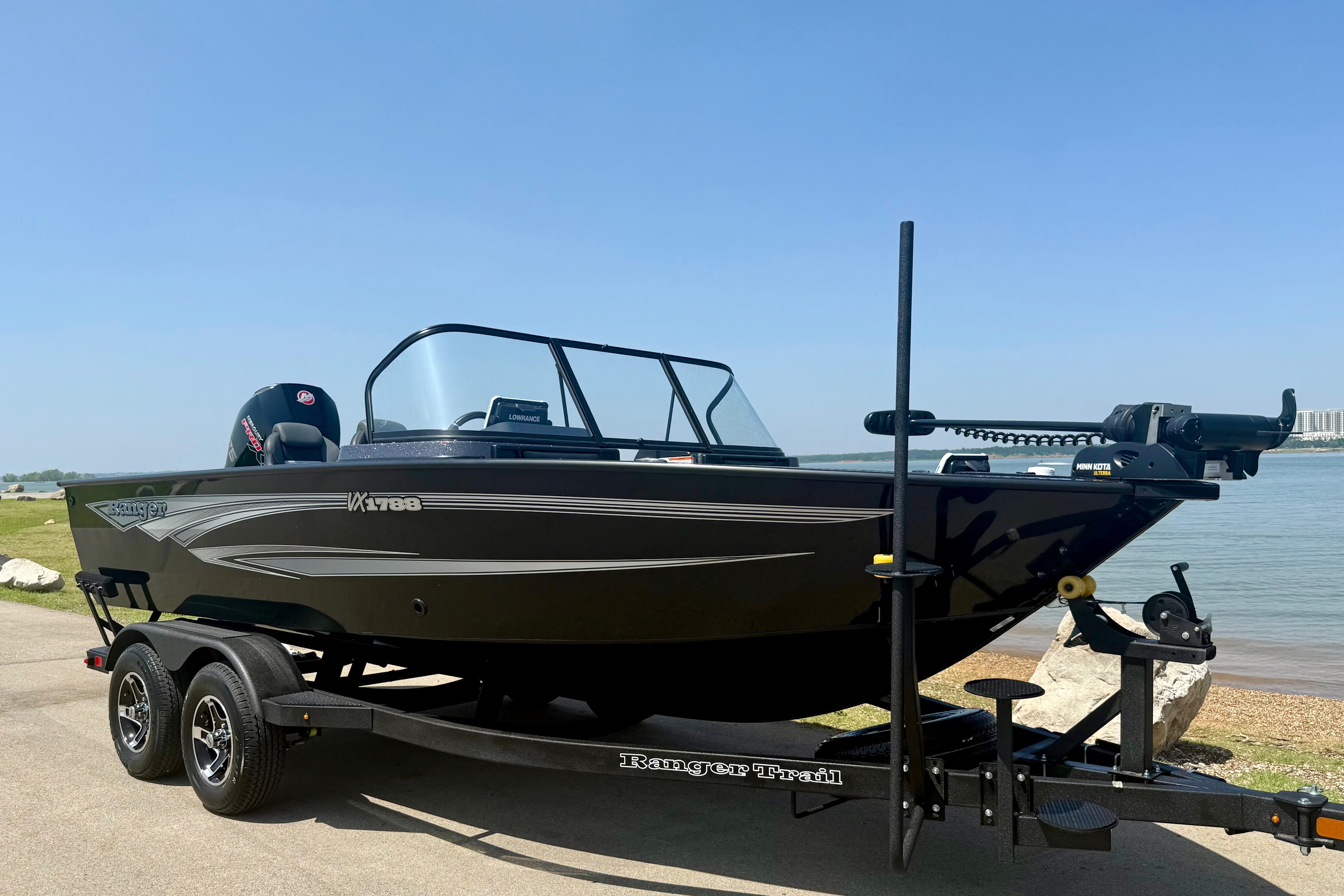 2026 Ranger VX1788 WT boat on trailer by a lake under clear blue sky.