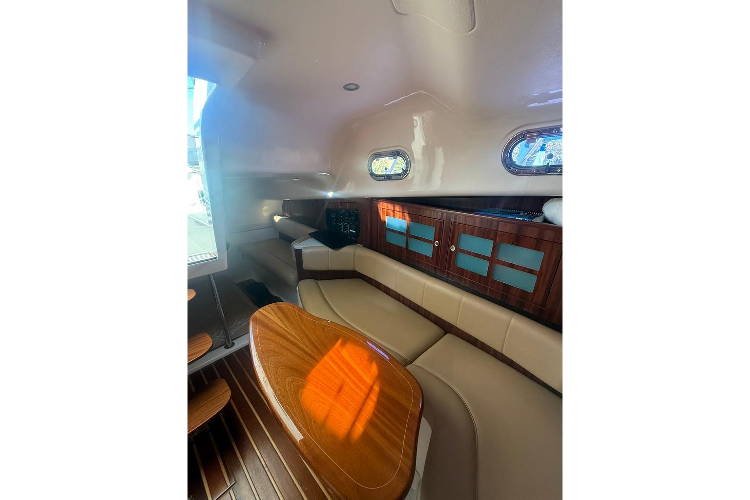 Interior of 2010 Pursuit OS 375 Offshore boat with elegant seating and wooden cabinetry.