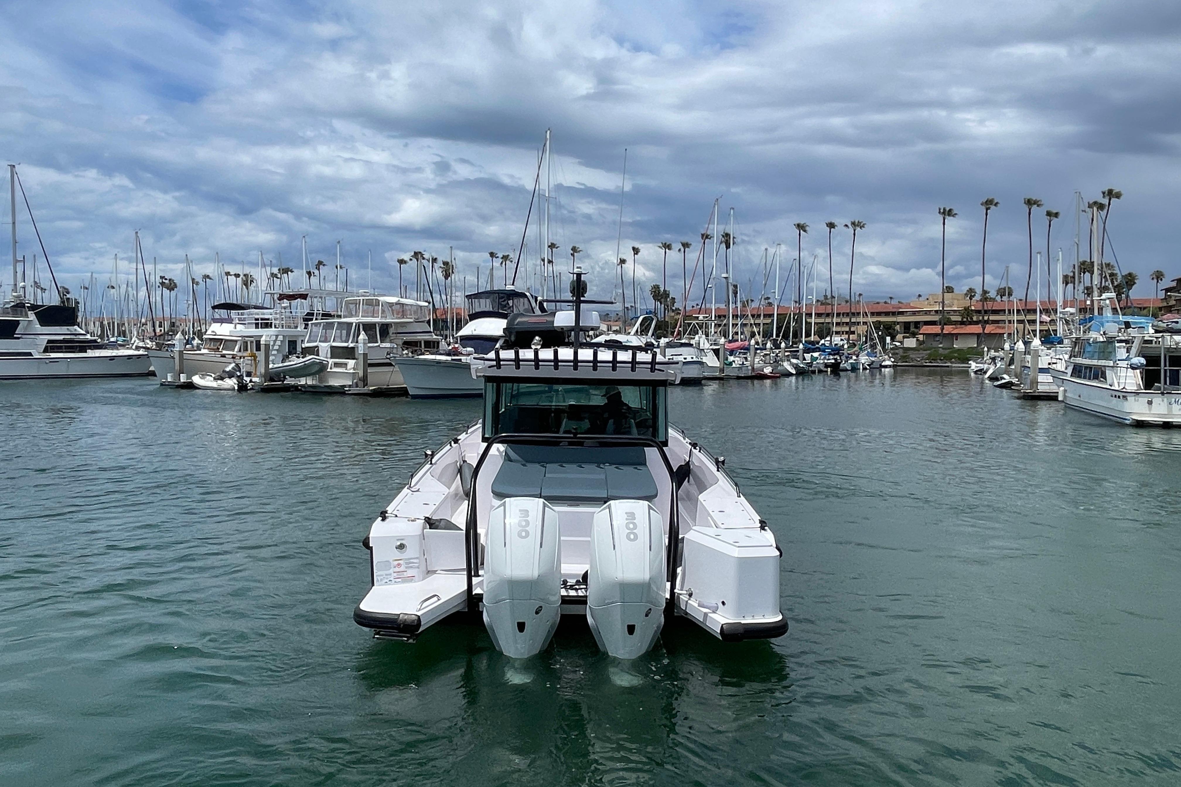 2023 Axopar Brabus 37 XC in harbor with boats and palm trees.
