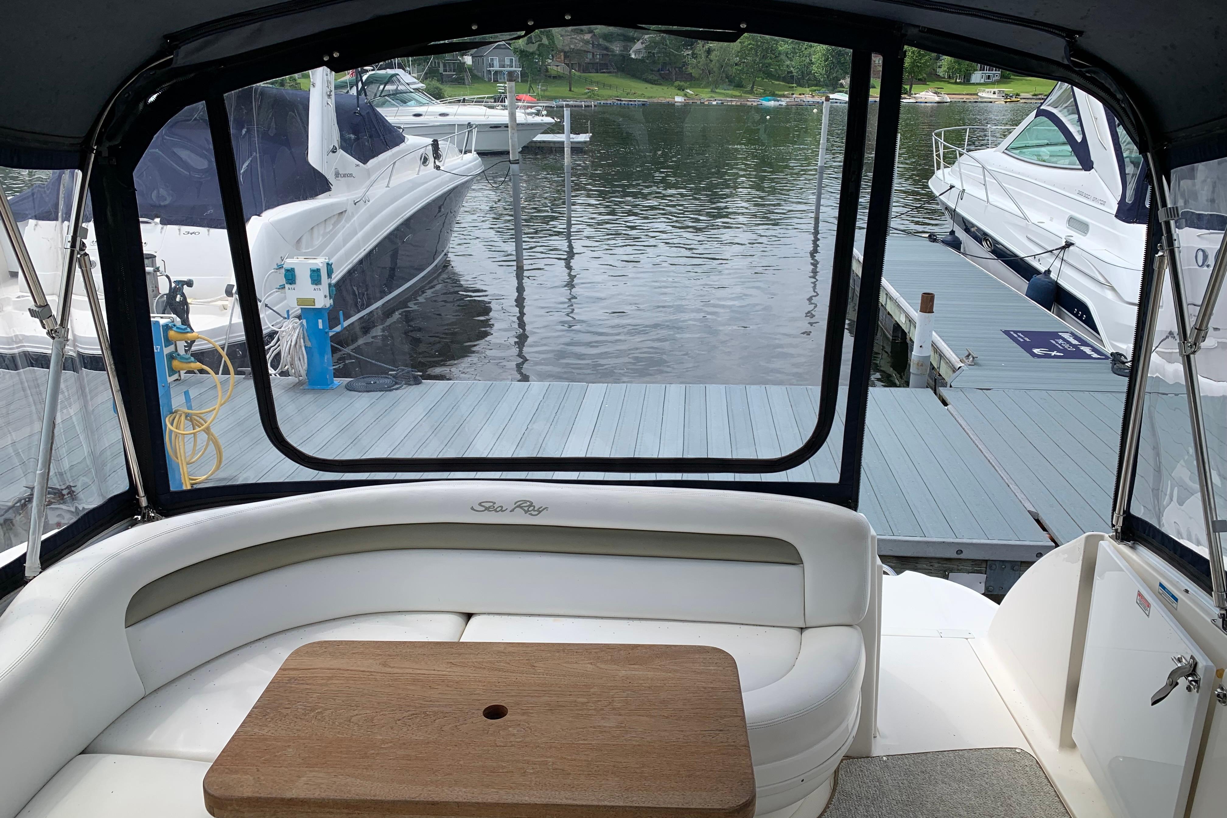 2007 Sea Ray 340 Sundancer interior view at marina dock, featuring seating and table.
