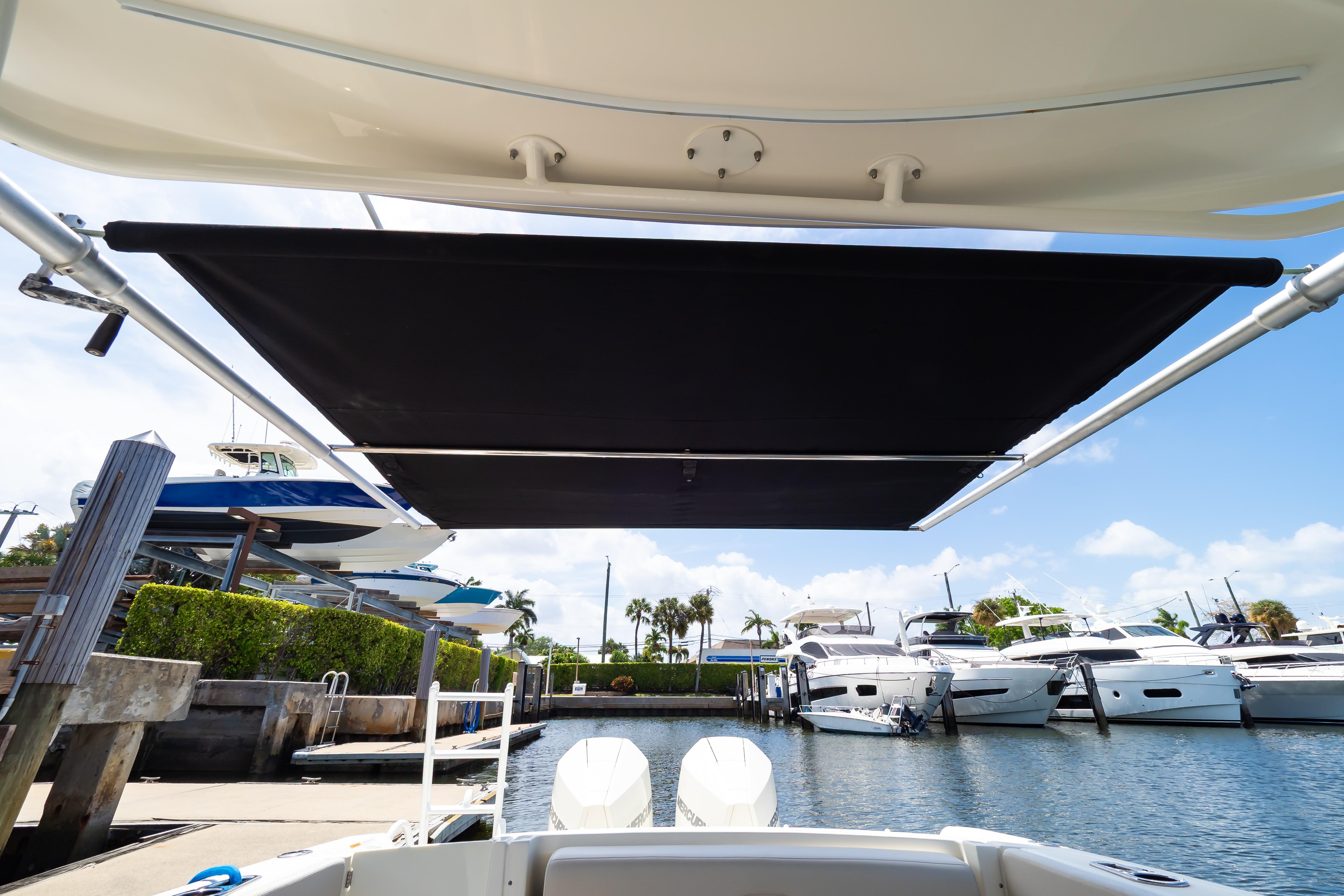 2019 Boston Whaler 270 Vantage with sunshade, docked at marina with yachts.