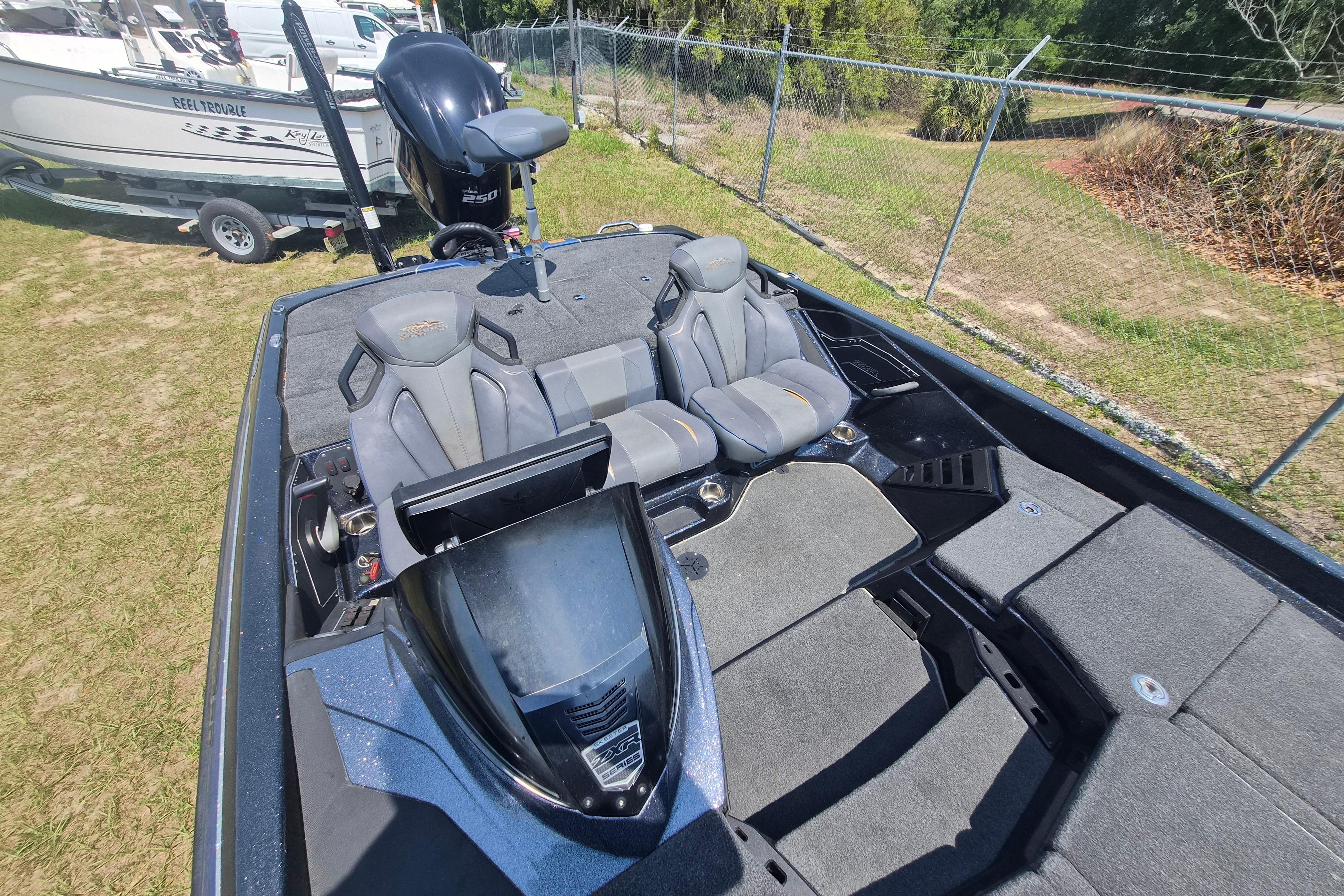 2021 Skeeter ZXR20 boat interior with seating and steering, parked on grass.