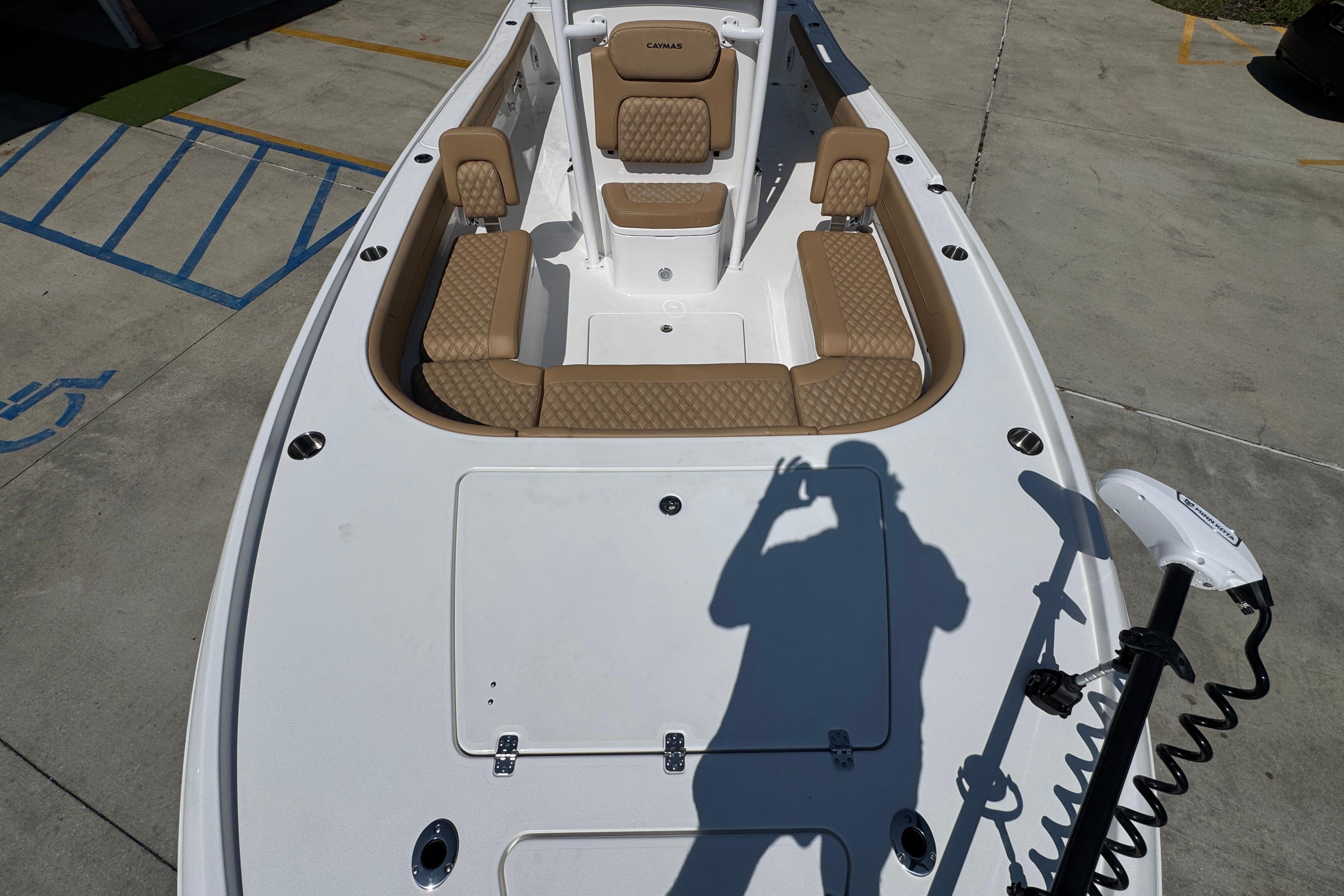 2027 Caymas 26 HB boat interior with tan seating and fishing equipment.