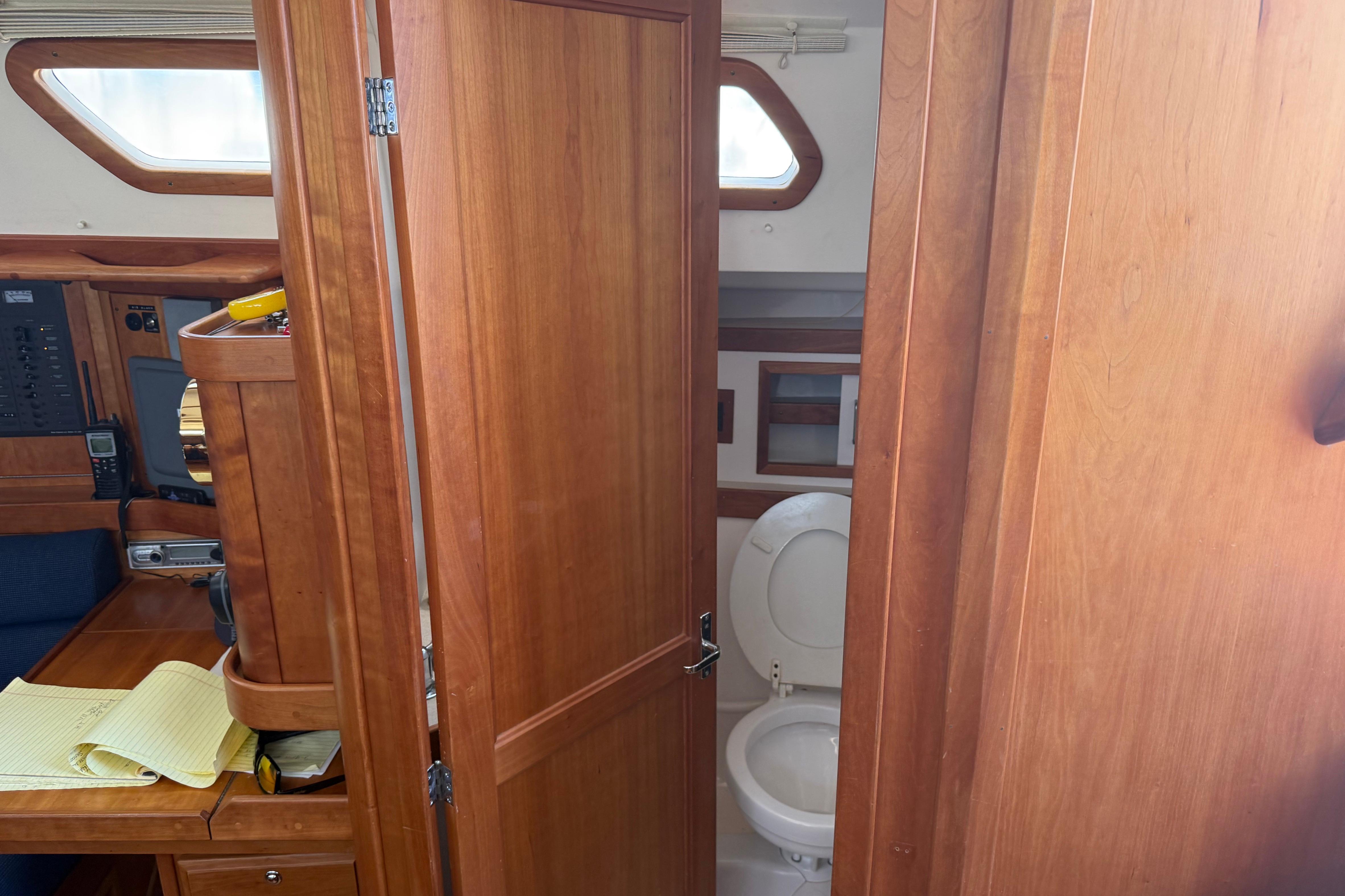 Interior of 2004 Sabre 386 sailboat showing wooden cabinetry and compact bathroom.