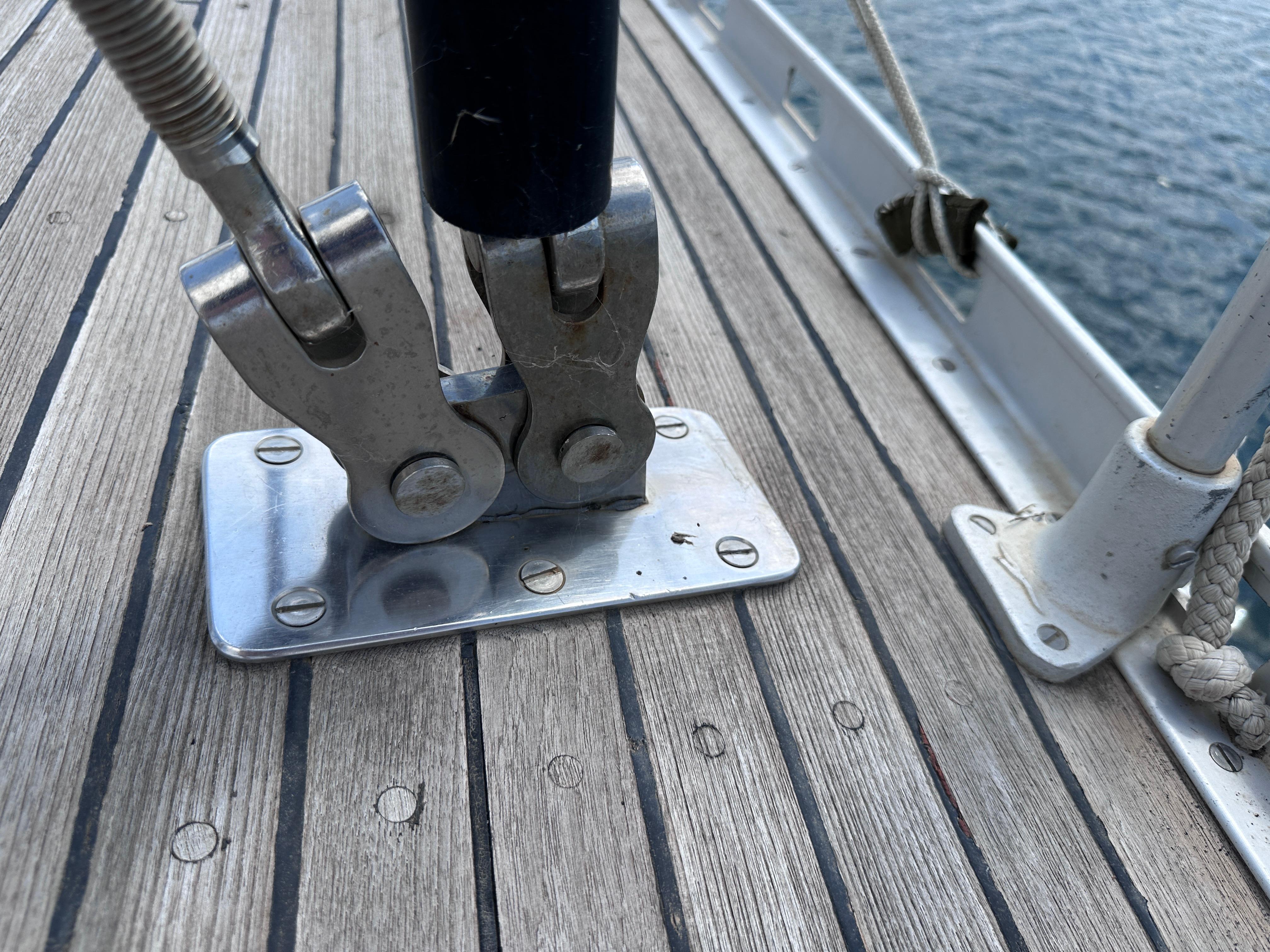 Deck fitting on a 1987 Standfast 50 sailboat, showcasing metal hardware and wooden decking.
