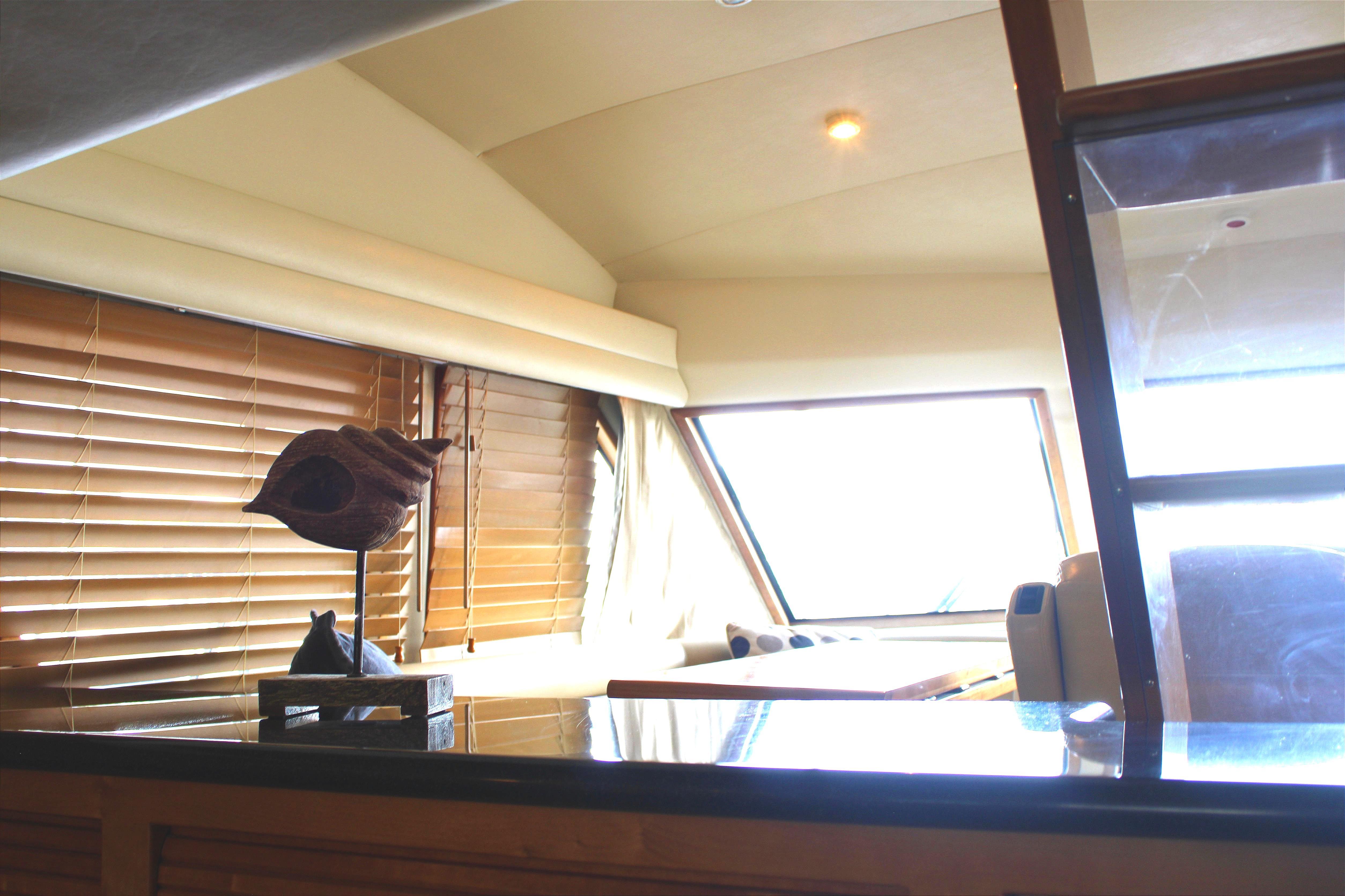 Interior of 2007 Navigator 5100 yacht with wooden blinds and modern decor.