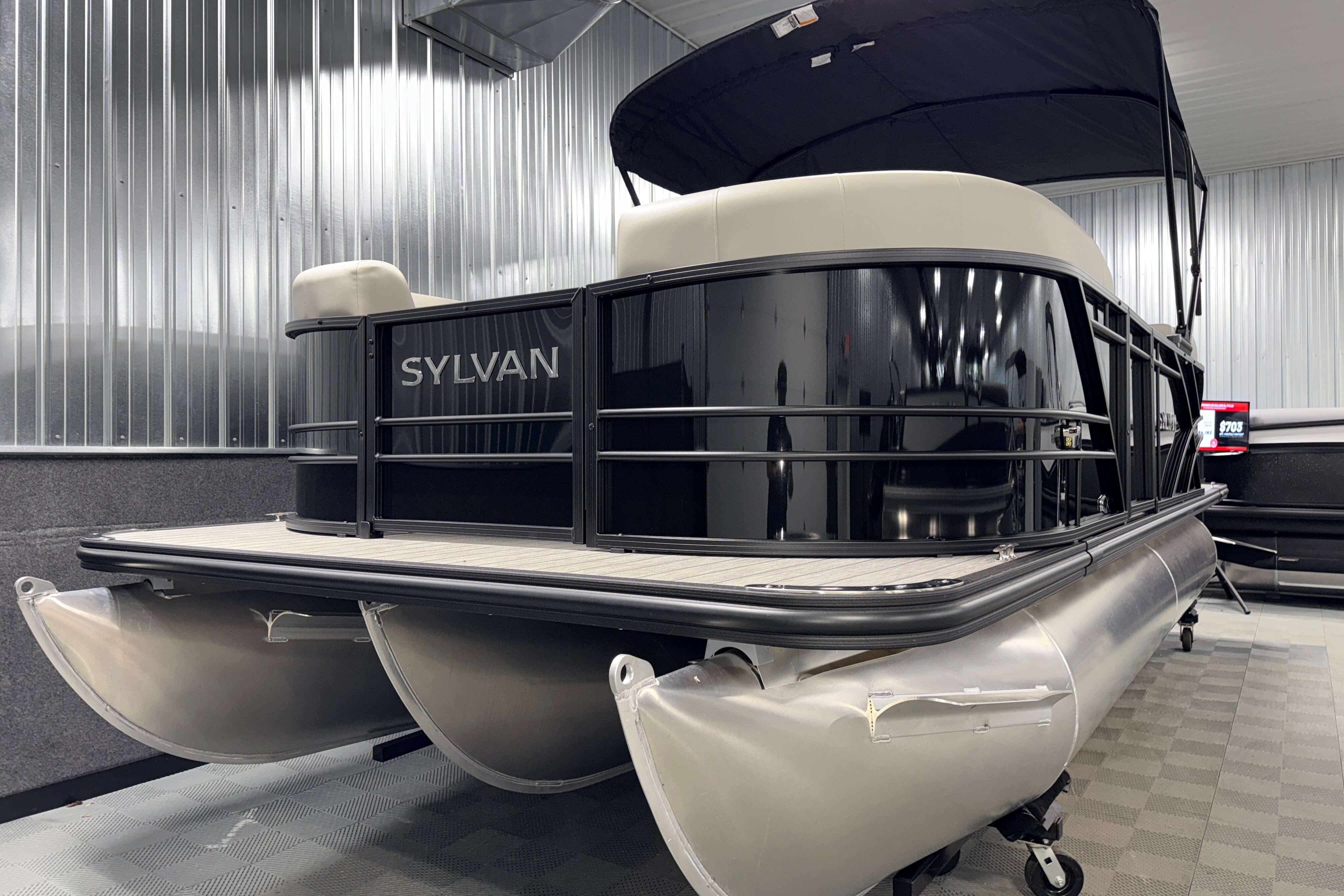 2026 Sylvan Mirage X1 pontoon boat in a showroom, featuring sleek design and modern amenities.