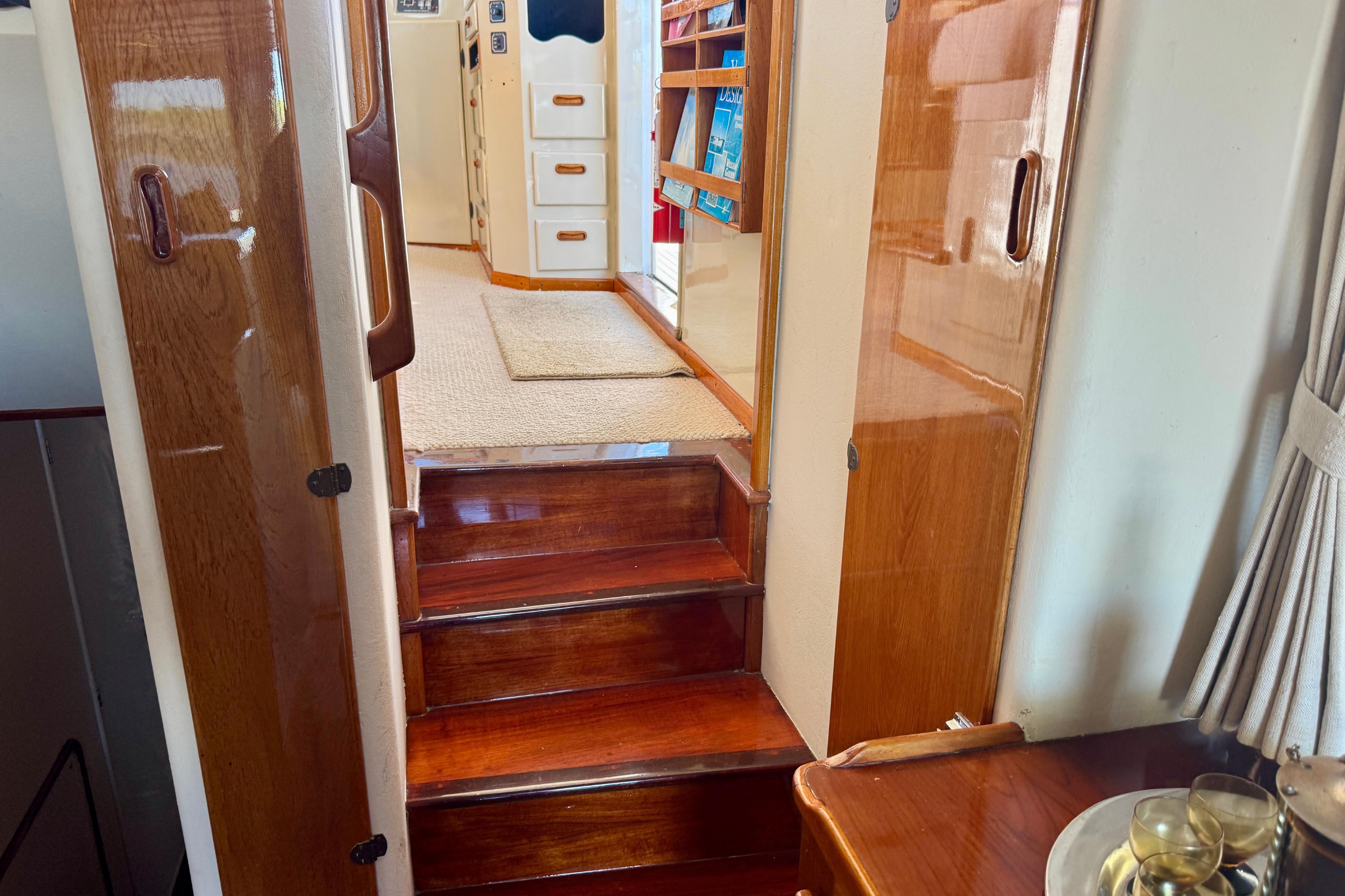 Interior of a 1958 Blanchard Pilothouse boat with polished wood and carpeted steps.