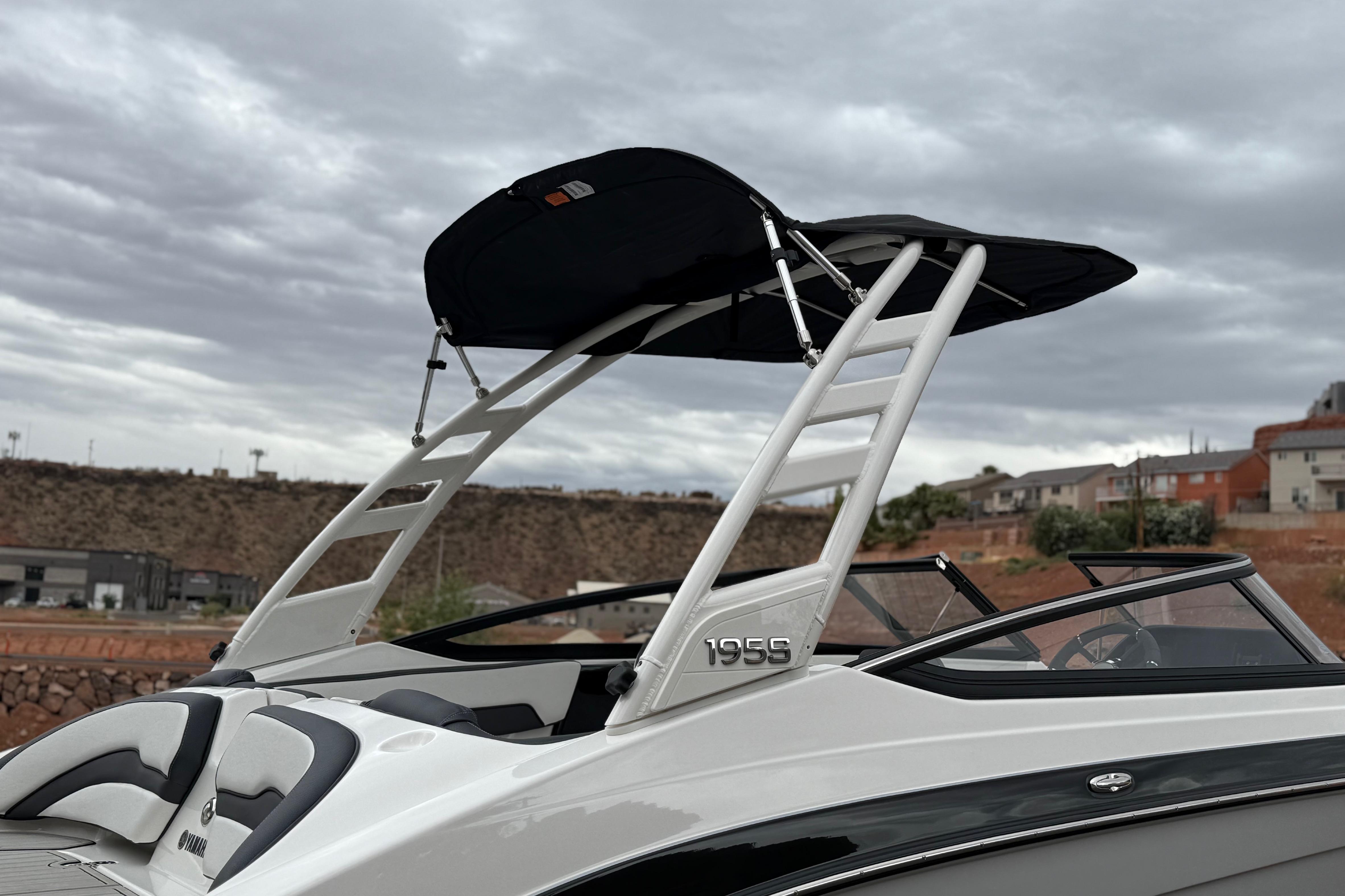 2025 Yamaha Boats 195S with sleek design and canopy against cloudy sky.