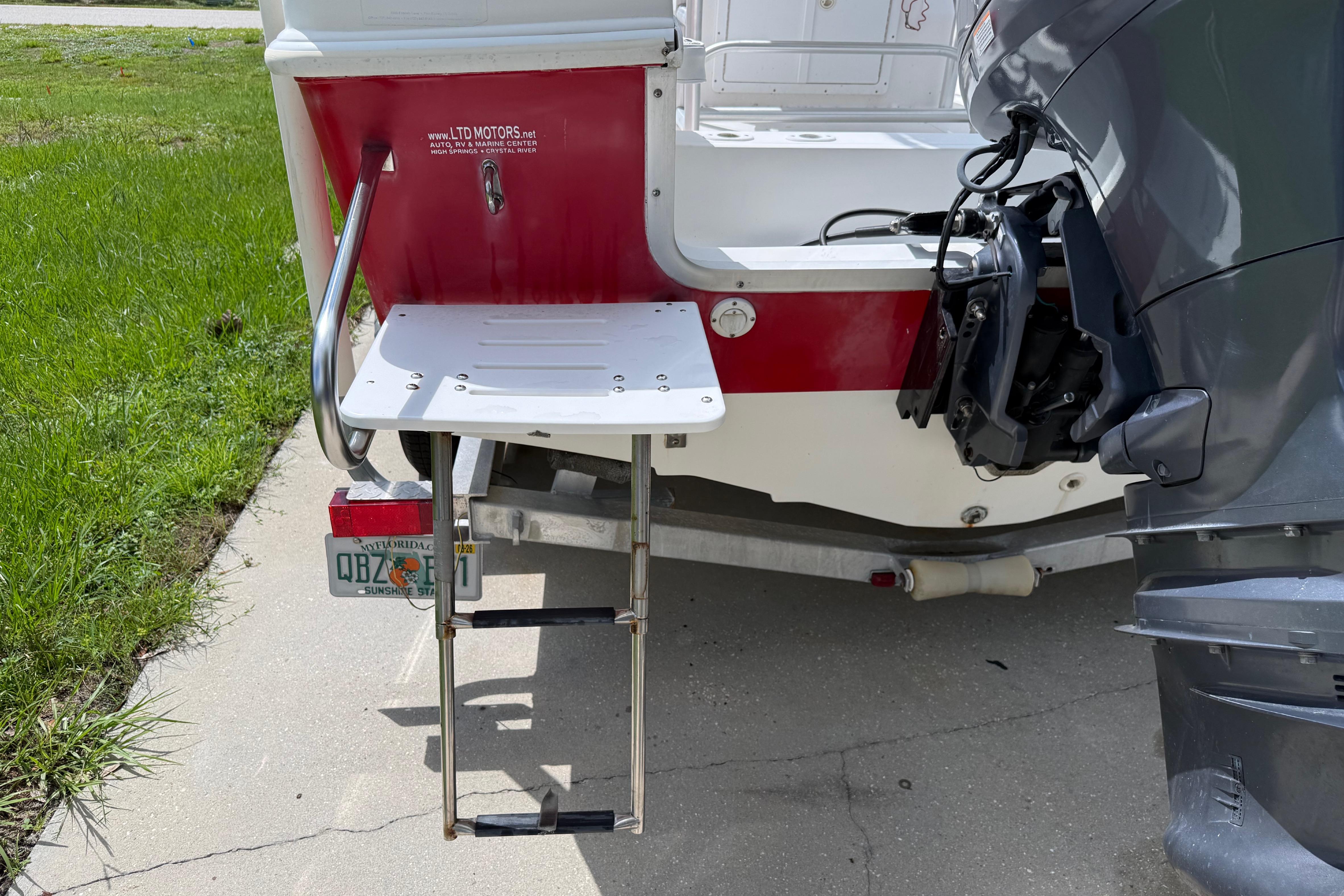 Rear view of a 2012 Clearwater 2000 Center Console boat with ladder and motor.