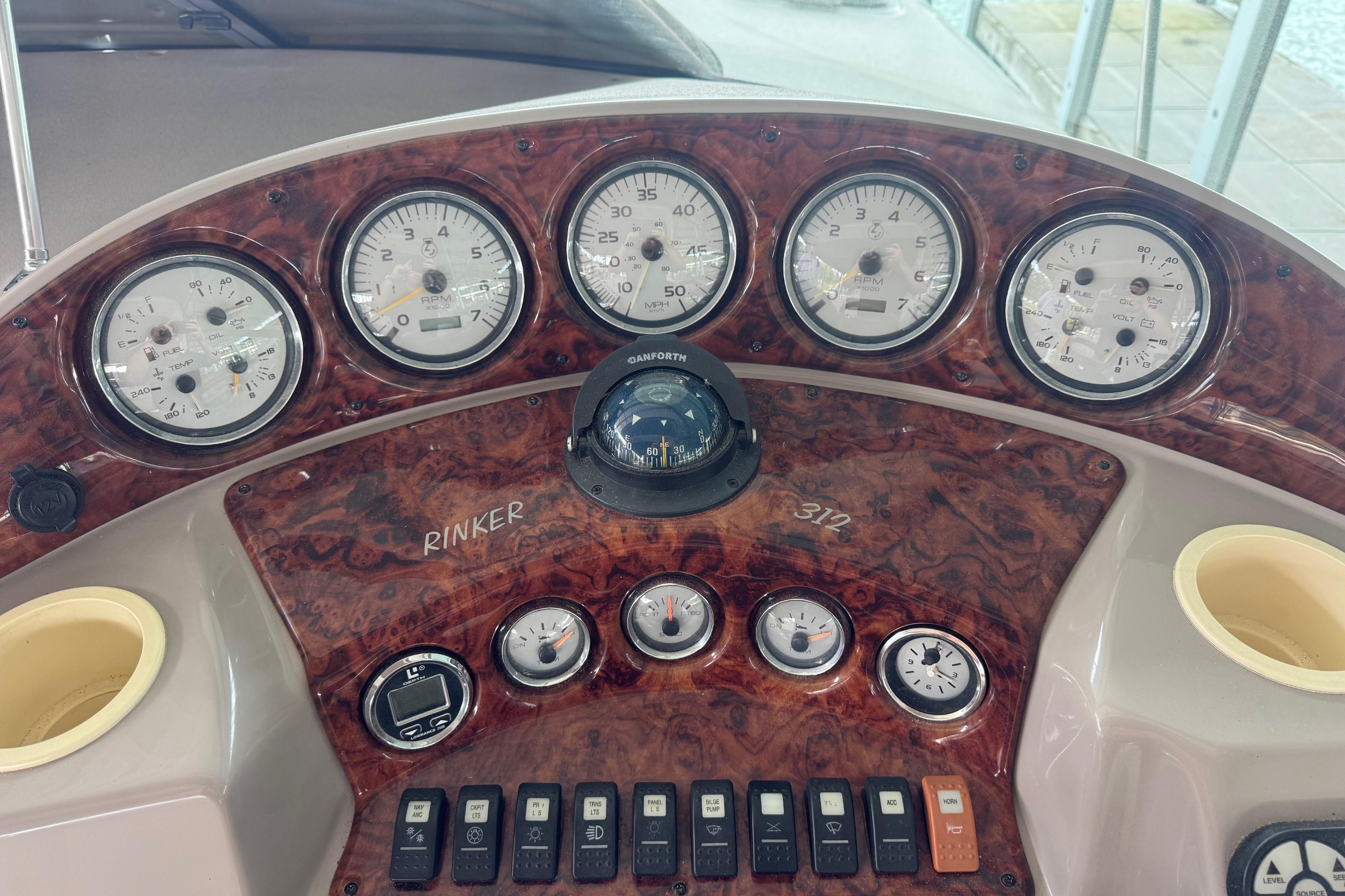 Dashboard of a 2004 Rinker Fiesta Vee 312 boat with gauges and controls.