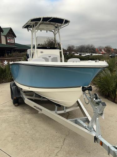 2024 Mako 214 CC boat on trailer, blue hull, center console, T-top, outdoor display.