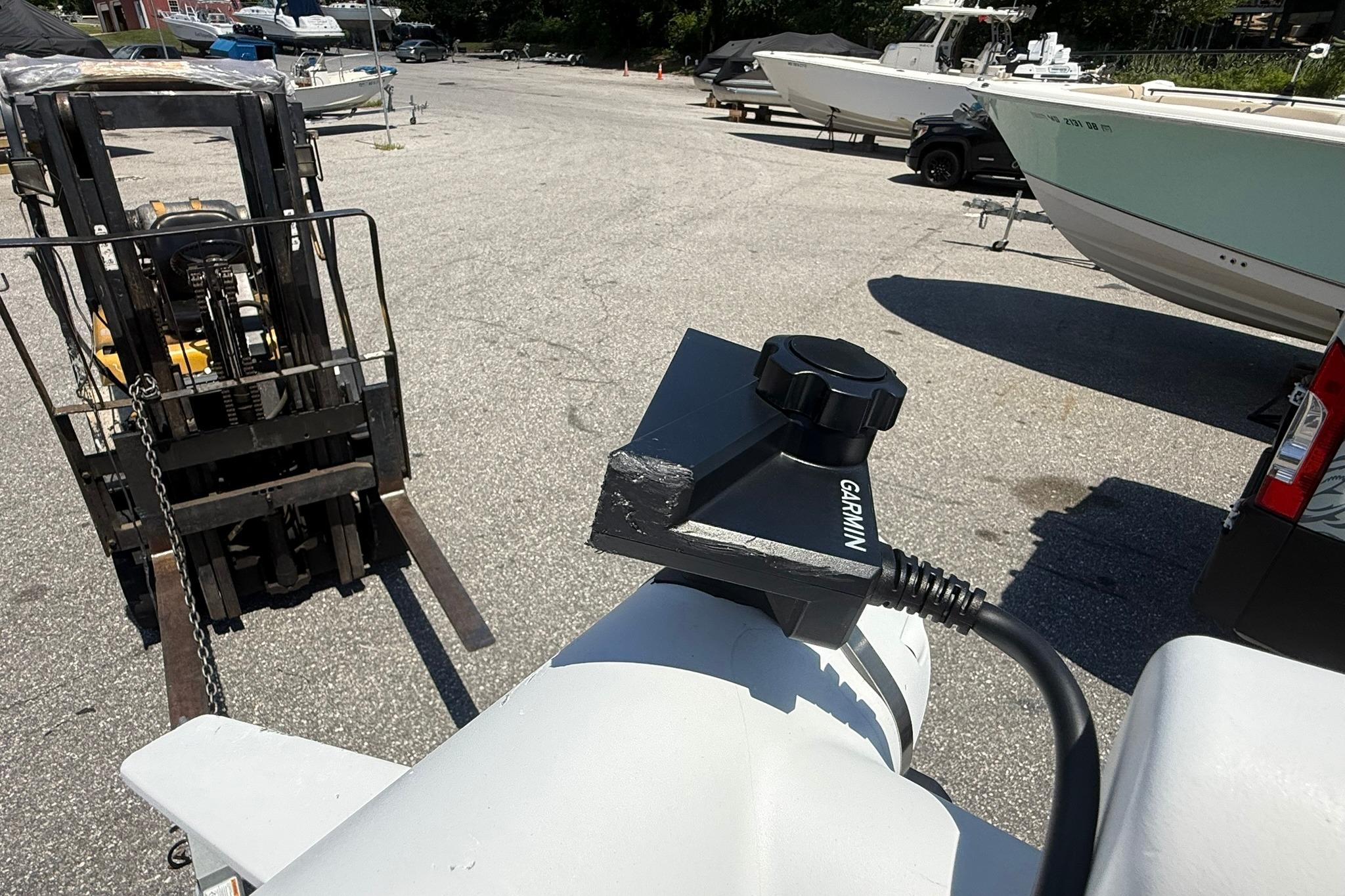 Forklift near 2024 Pair Customs 24 Center Console MV boat with Garmin equipment.
