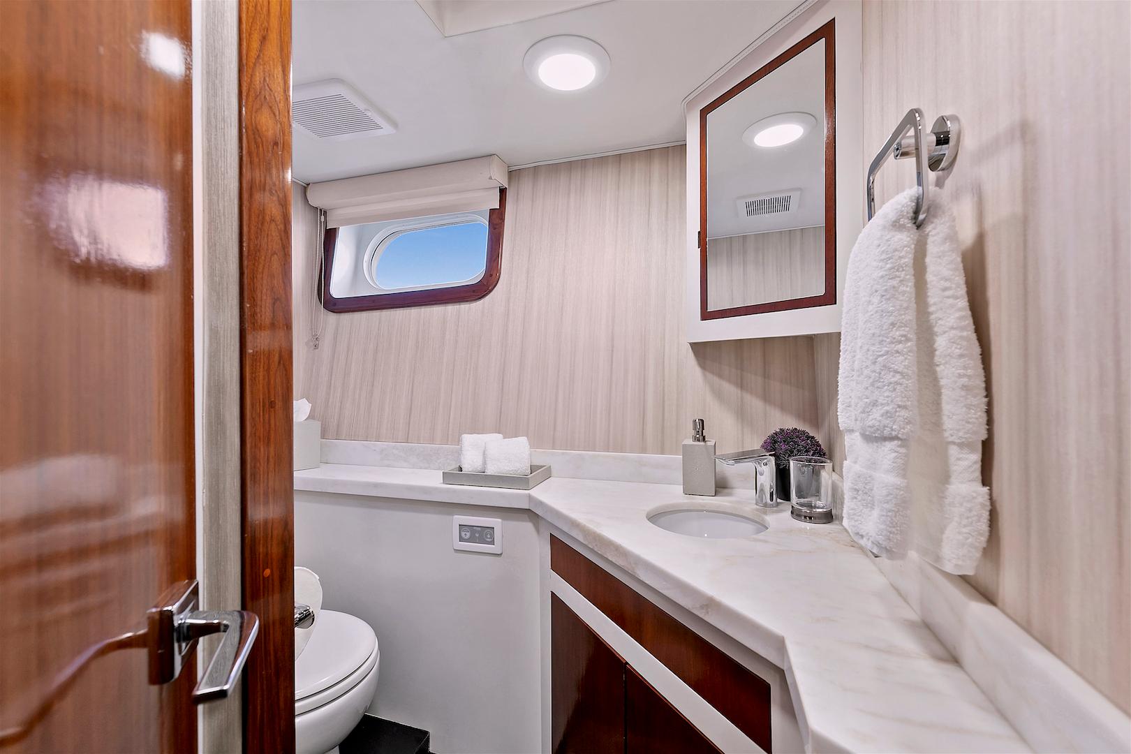 Luxurious bathroom on 1987 Deep Sea Marine motor yacht with elegant wood and marble finishes.