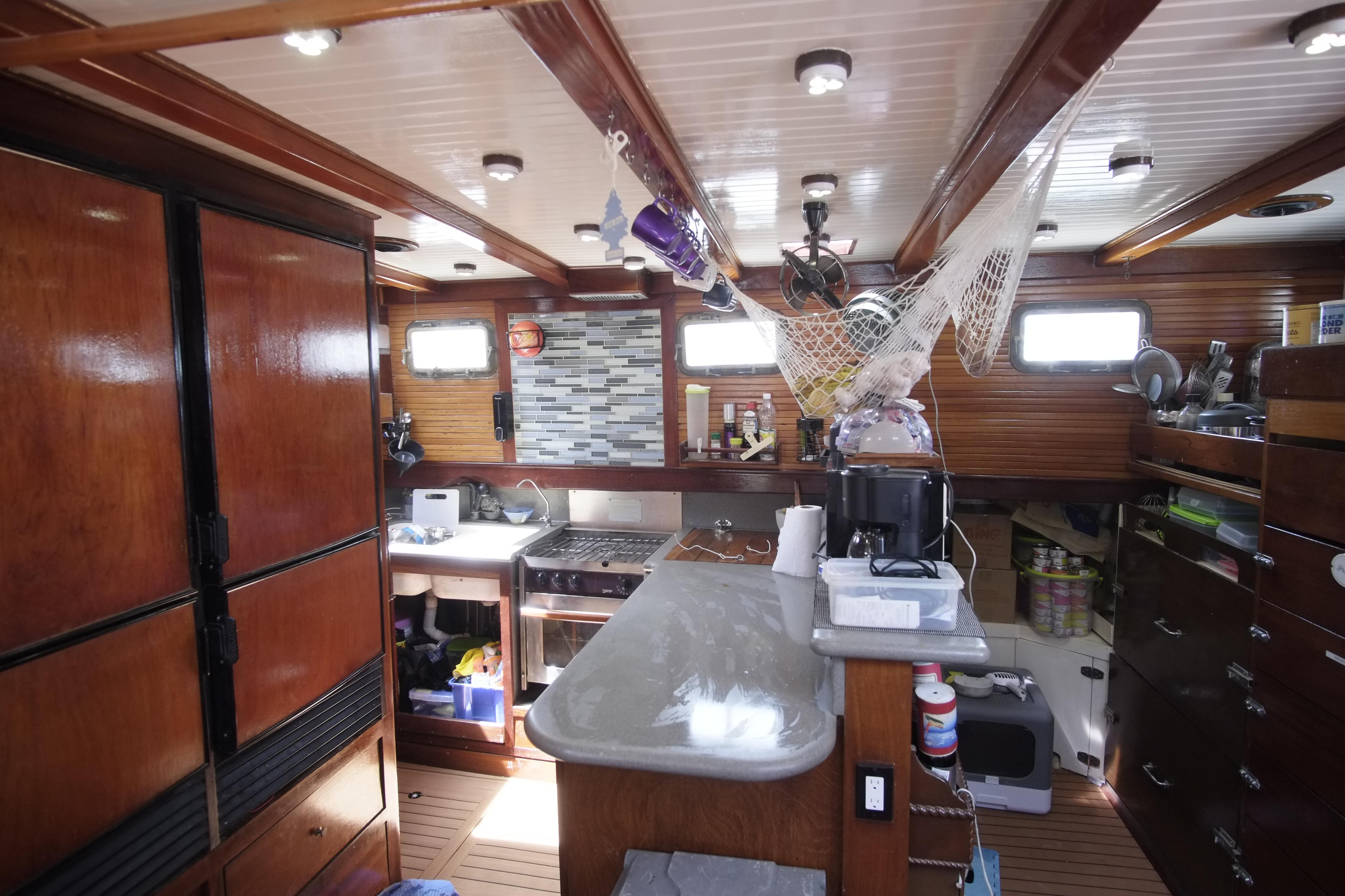 Interior of 2006 Custom Bud Macintosh schooner with wooden cabinetry and modern kitchen amenities.