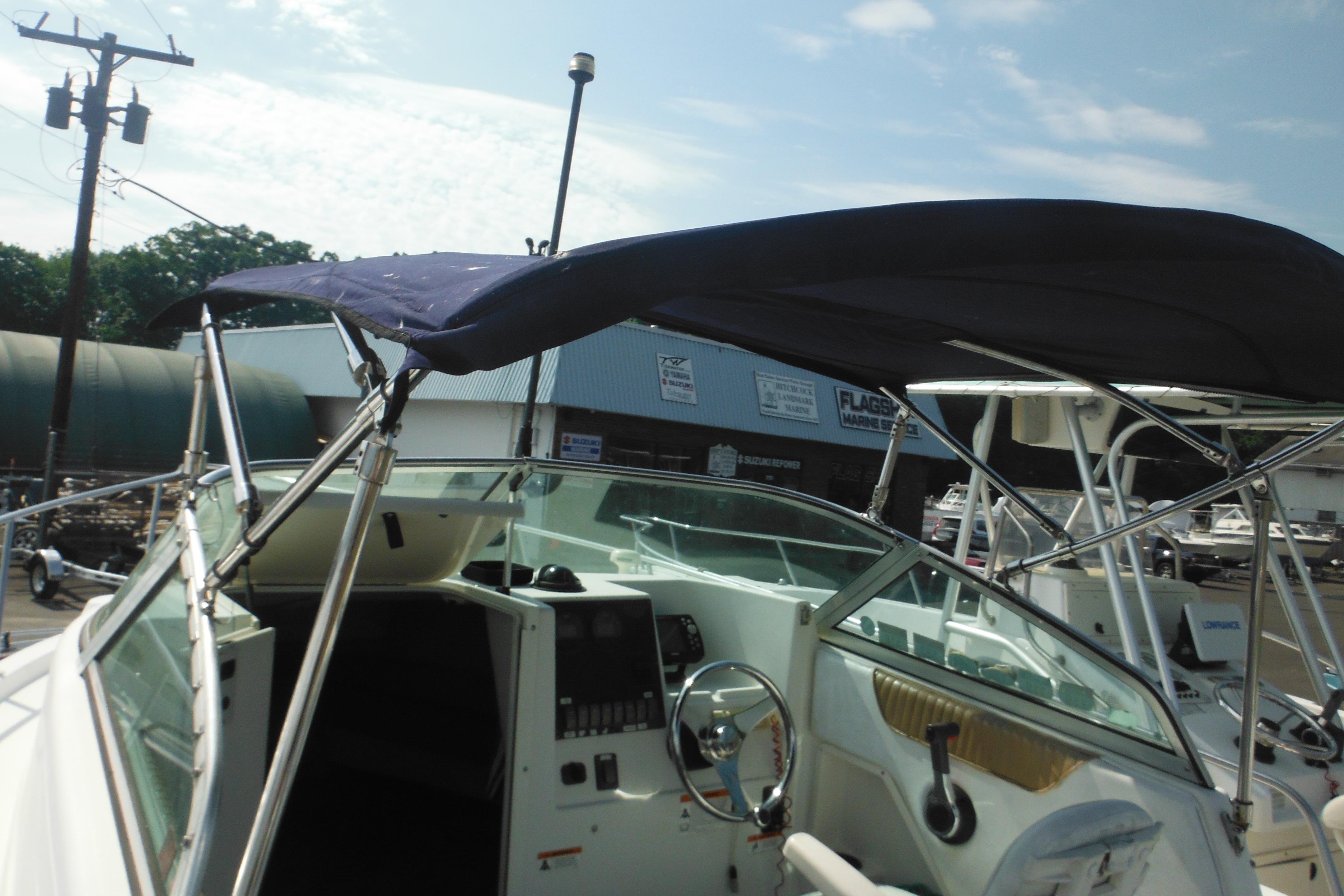 2005 Seaswirl Striper 2101 Walkaround O/B with canopy, parked outdoors under clear sky.