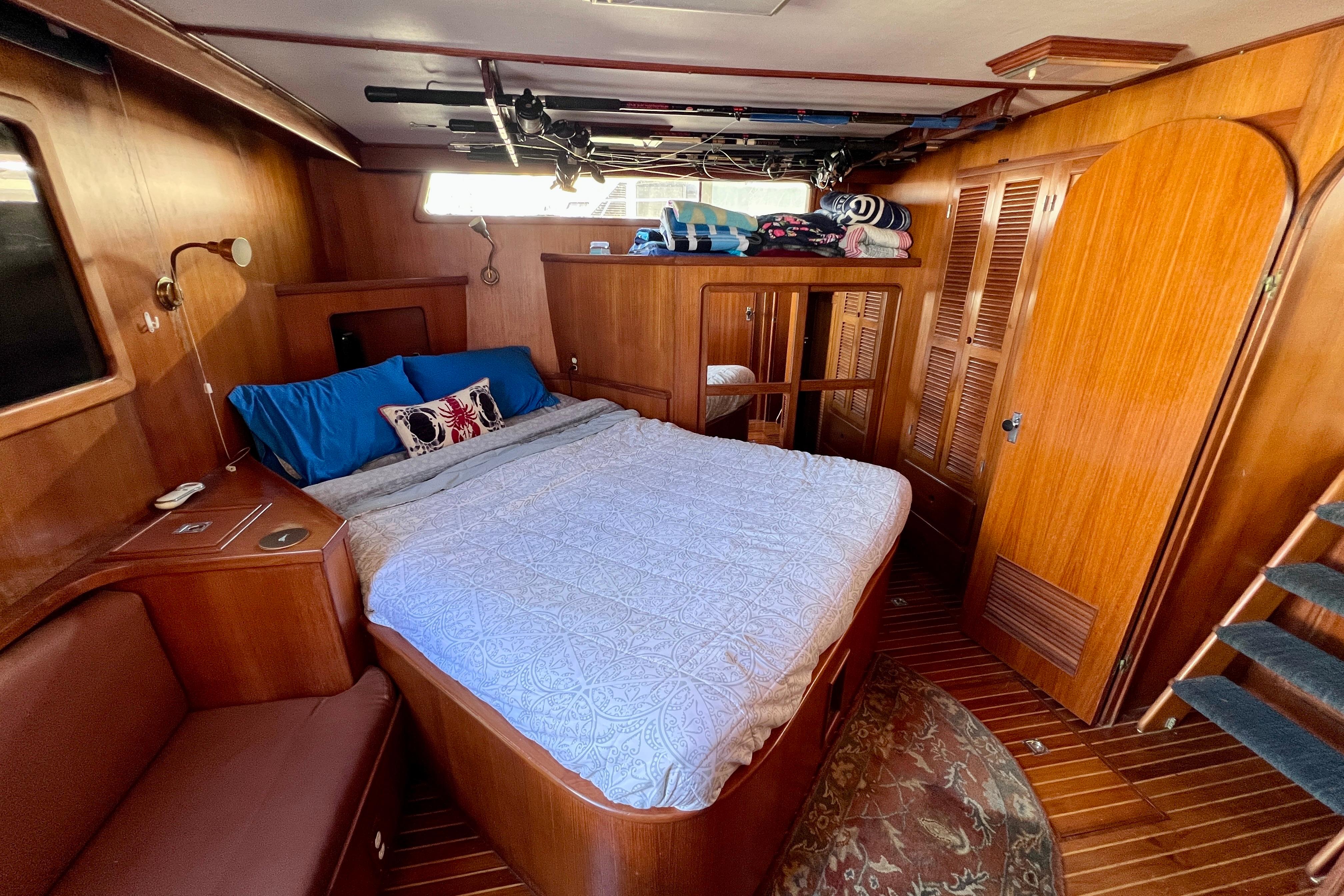 Cozy bedroom in 1984 Kha Shing Spoiler Cockpit Motor Yacht with wooden interior and double bed.