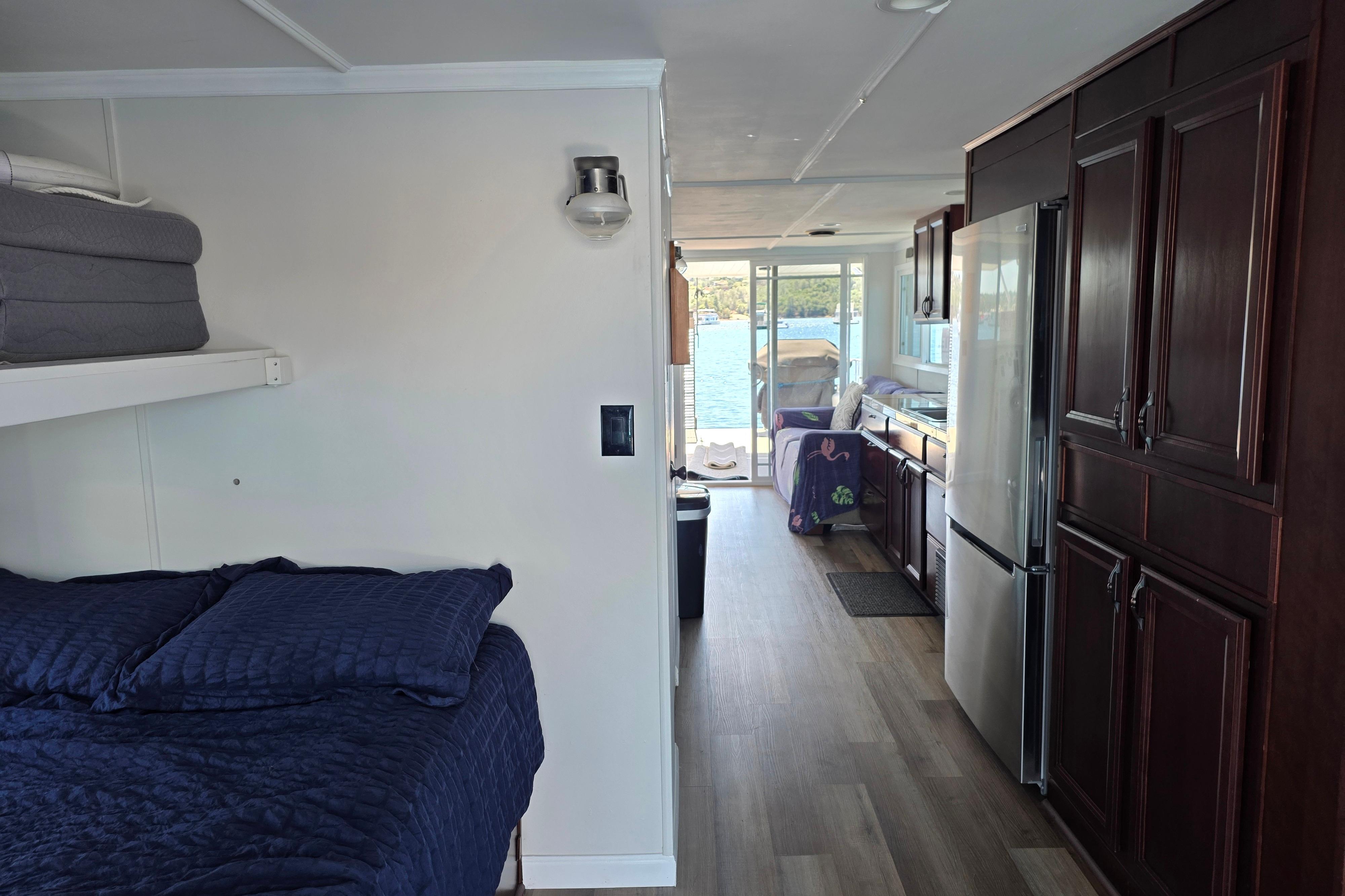 Interior of a 2007 custom houseboat with cozy bedroom and modern kitchen.