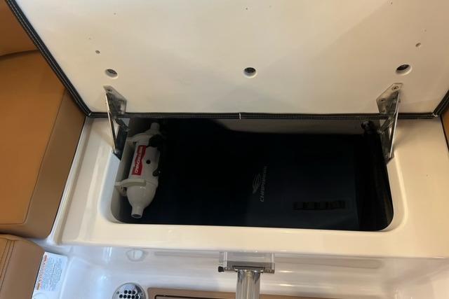 Storage compartment in a 2025 Chaparral 247 SSX boat, featuring a safety device.