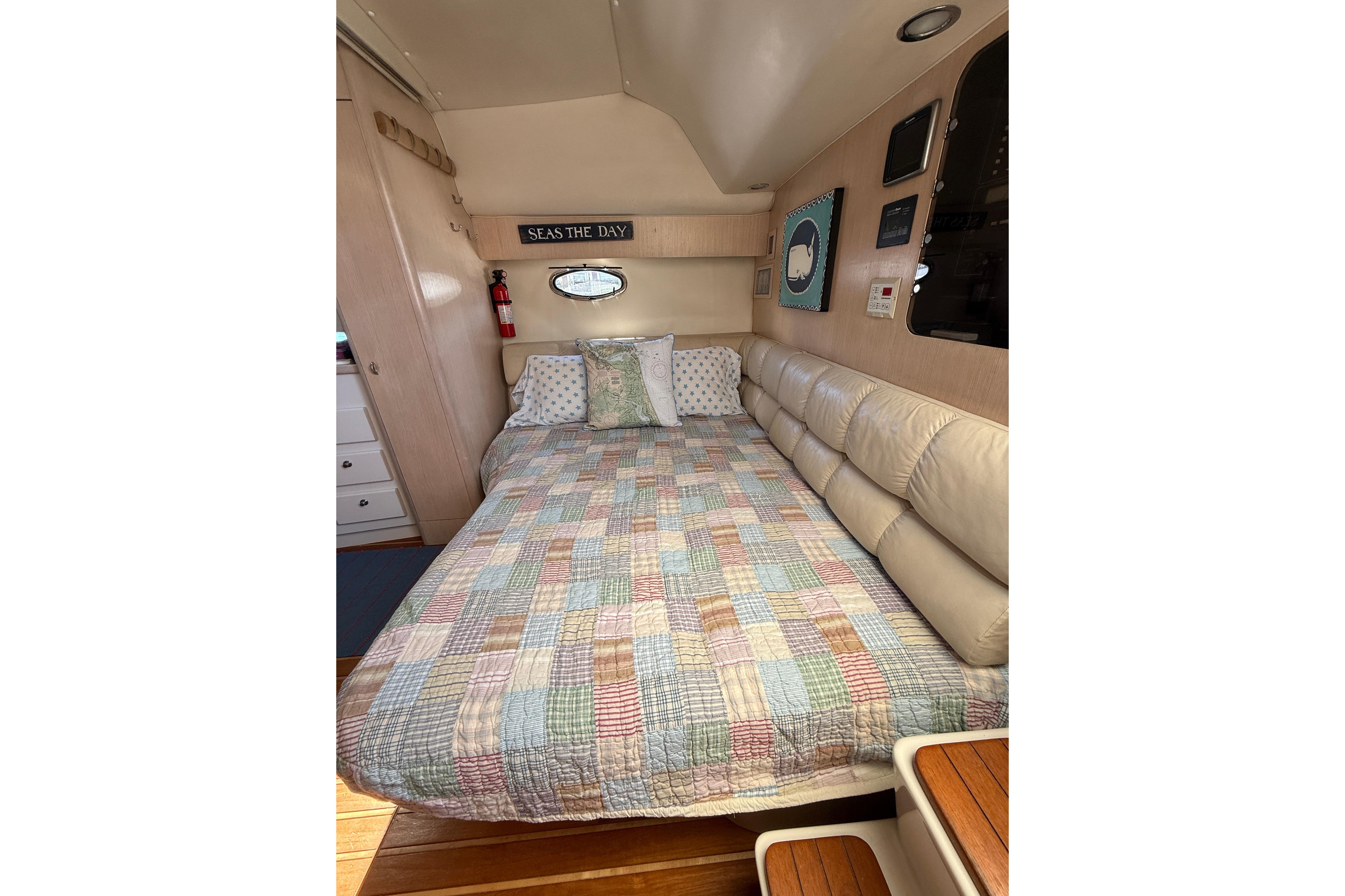 Cozy cabin interior of 1996 Tiara Yachts 3500 Express with quilted bedspread.