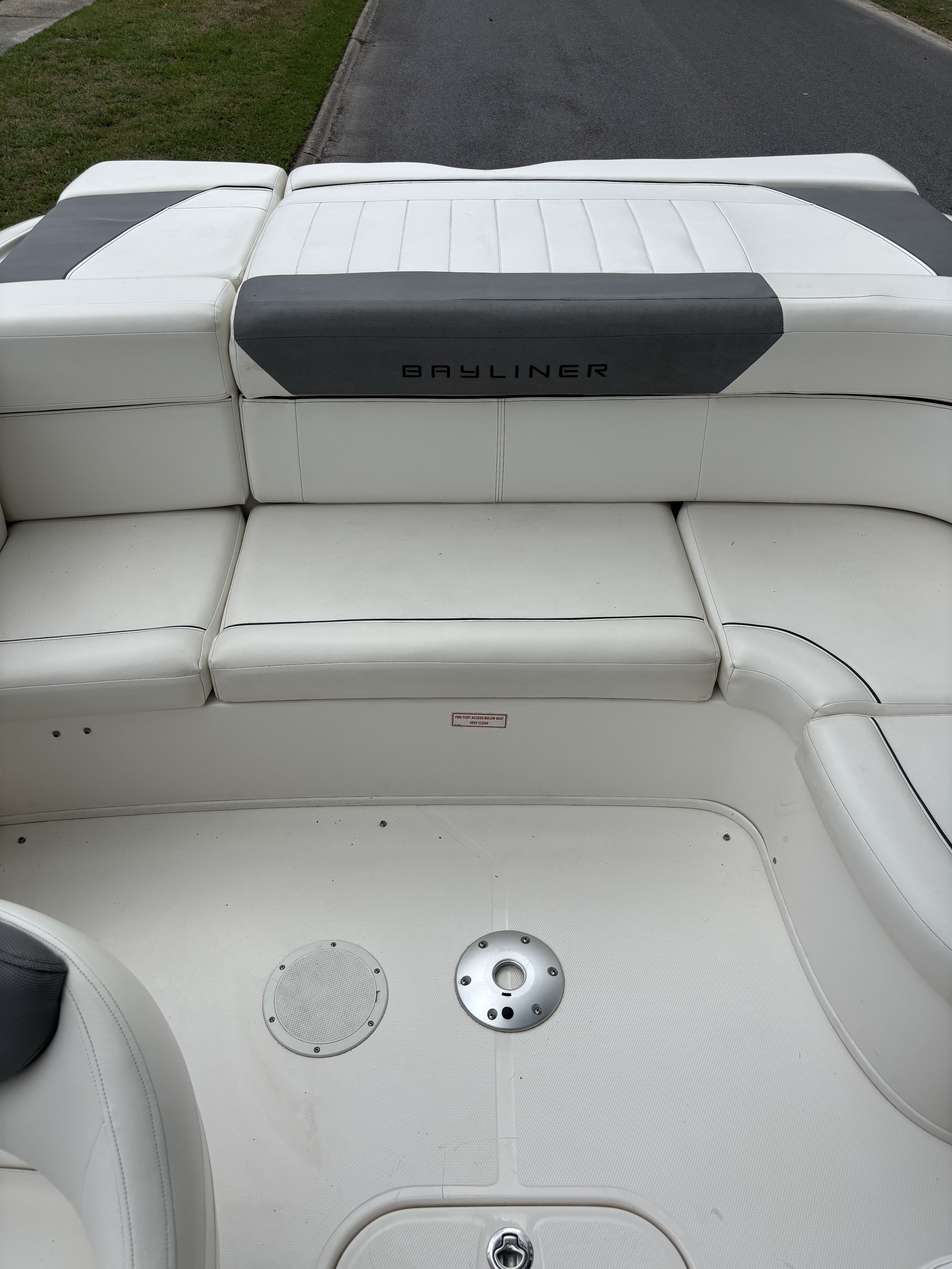 Interior view of a Bayliner 215 Bowrider with white upholstery and gray accents.