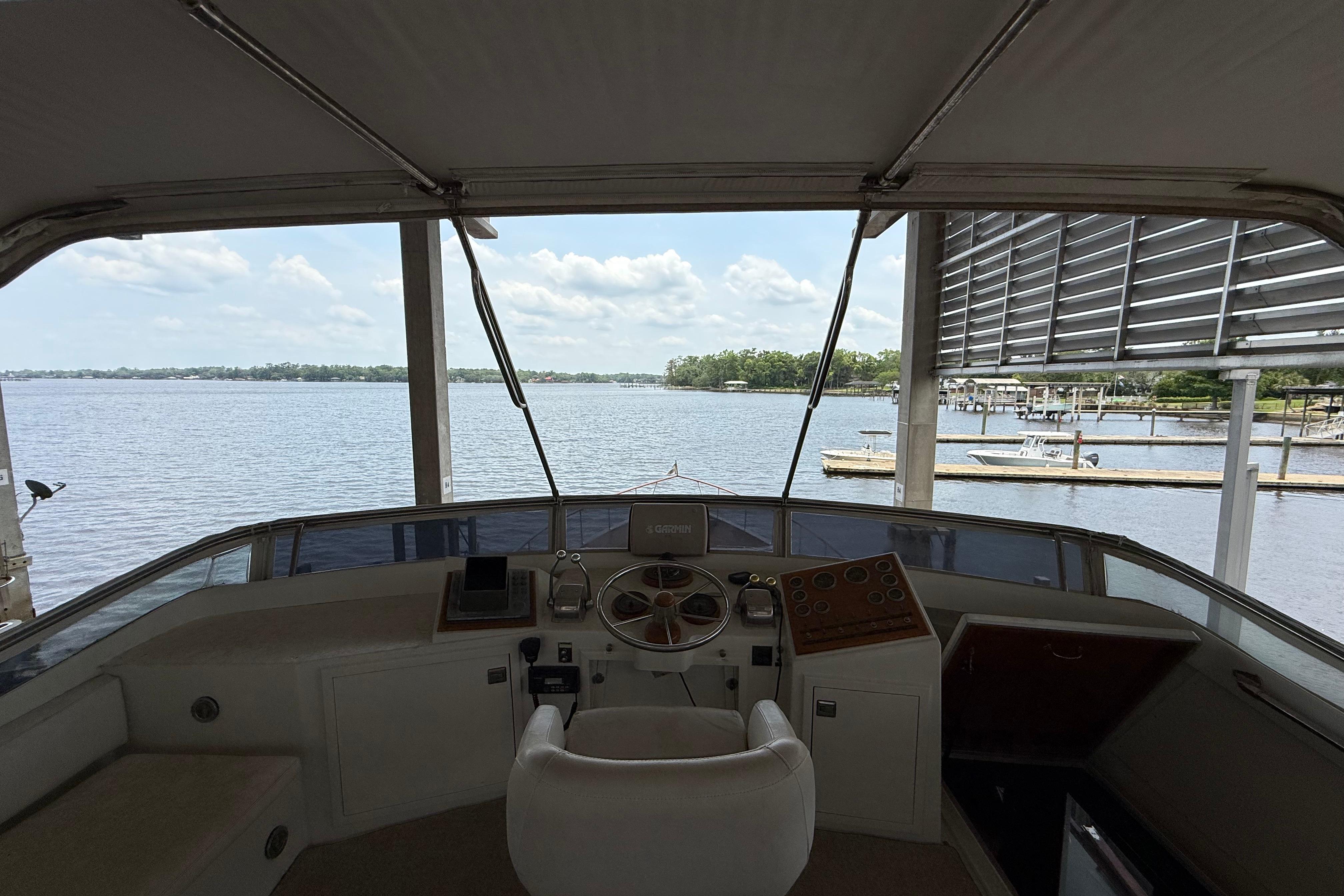 1974 Pacemaker Cockpit Motoryacht helm with scenic waterfront view.