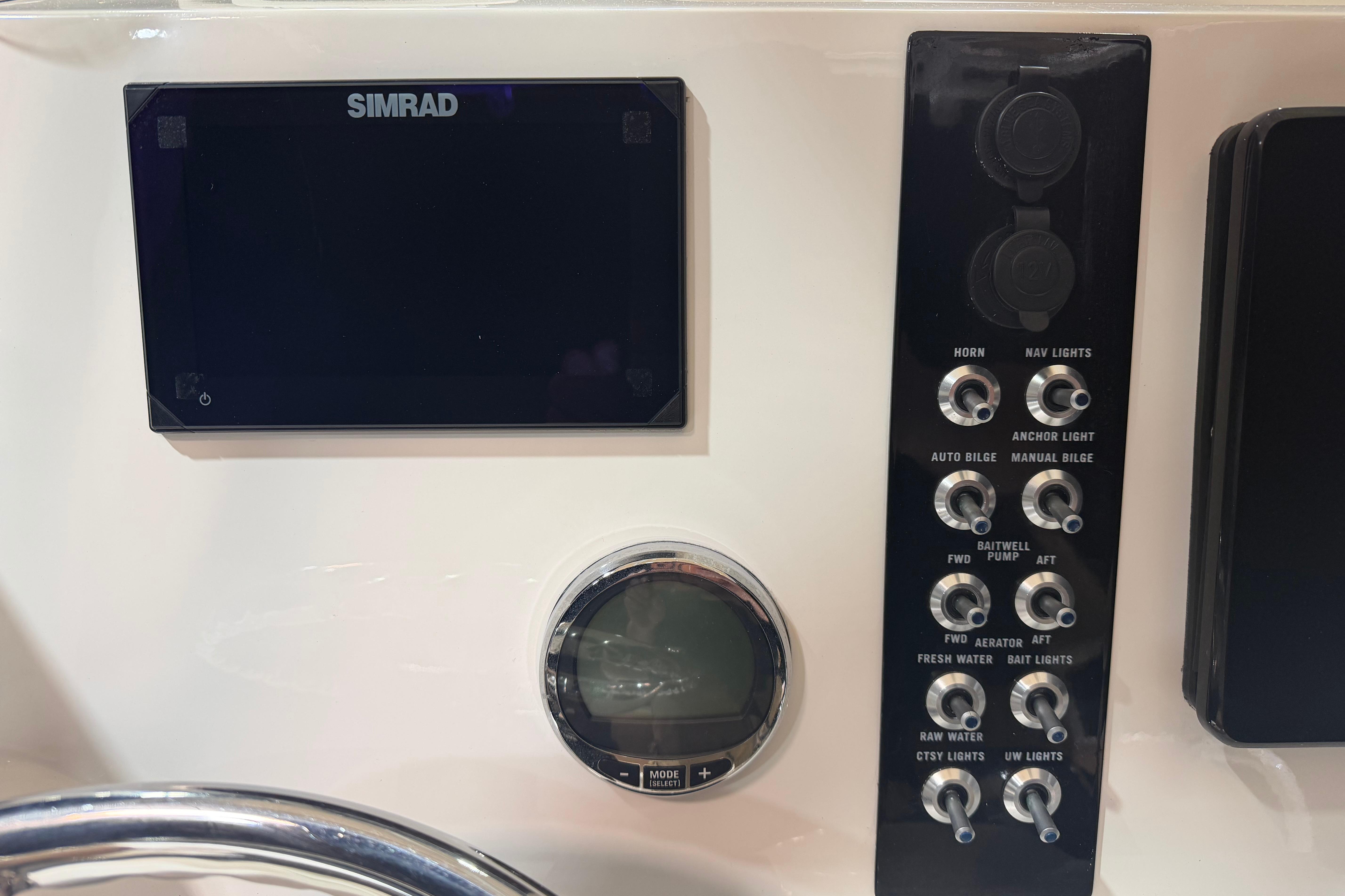 Control panel of 2023 NauticStar 215 XTS boat with Simrad display and switches.