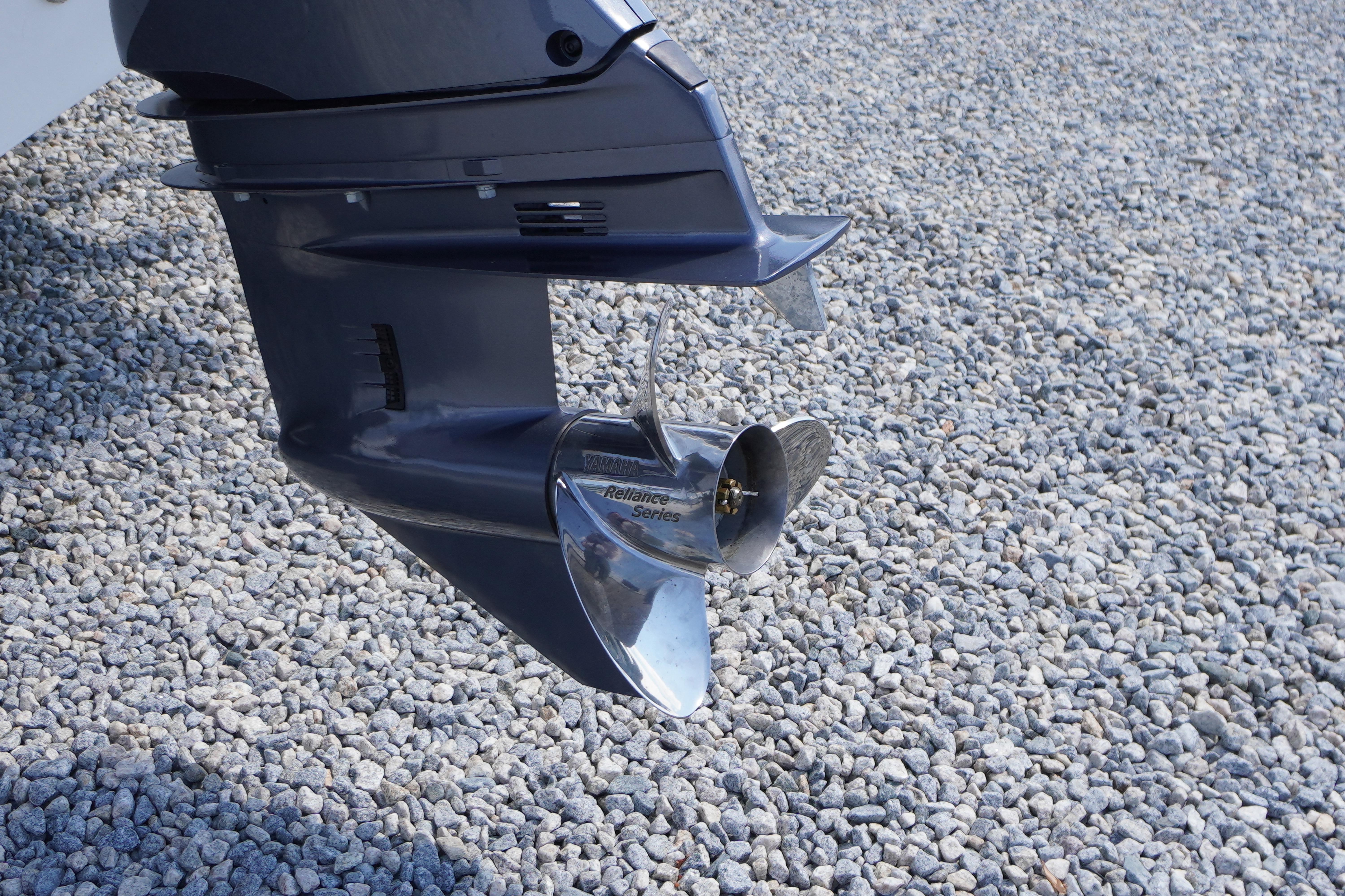 Outboard motor of 2026 Tidewater 220 CC Adventure on gravel surface.