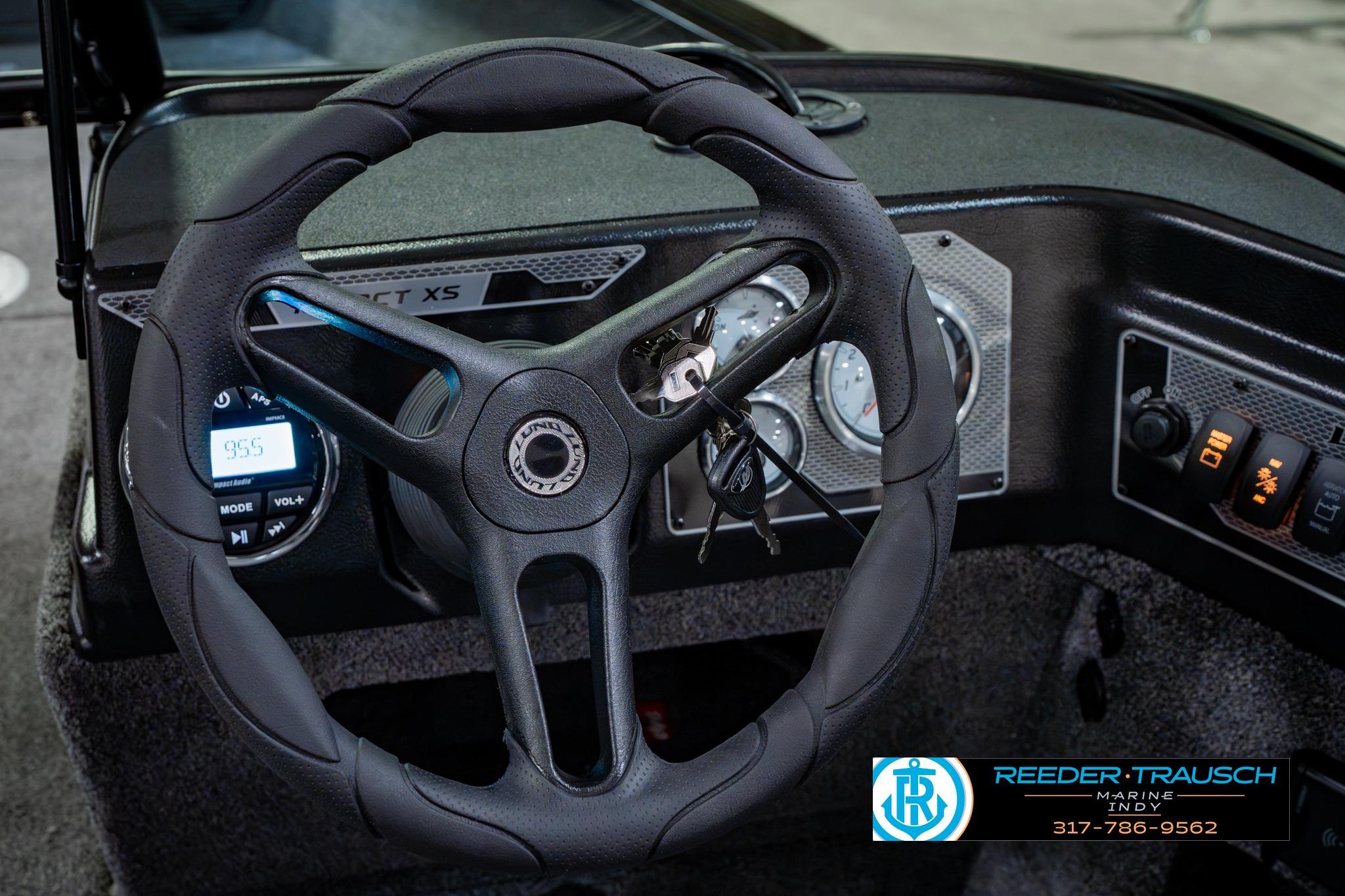 2026 Lund 1875 Impact XS boat dashboard with steering wheel and control panel.