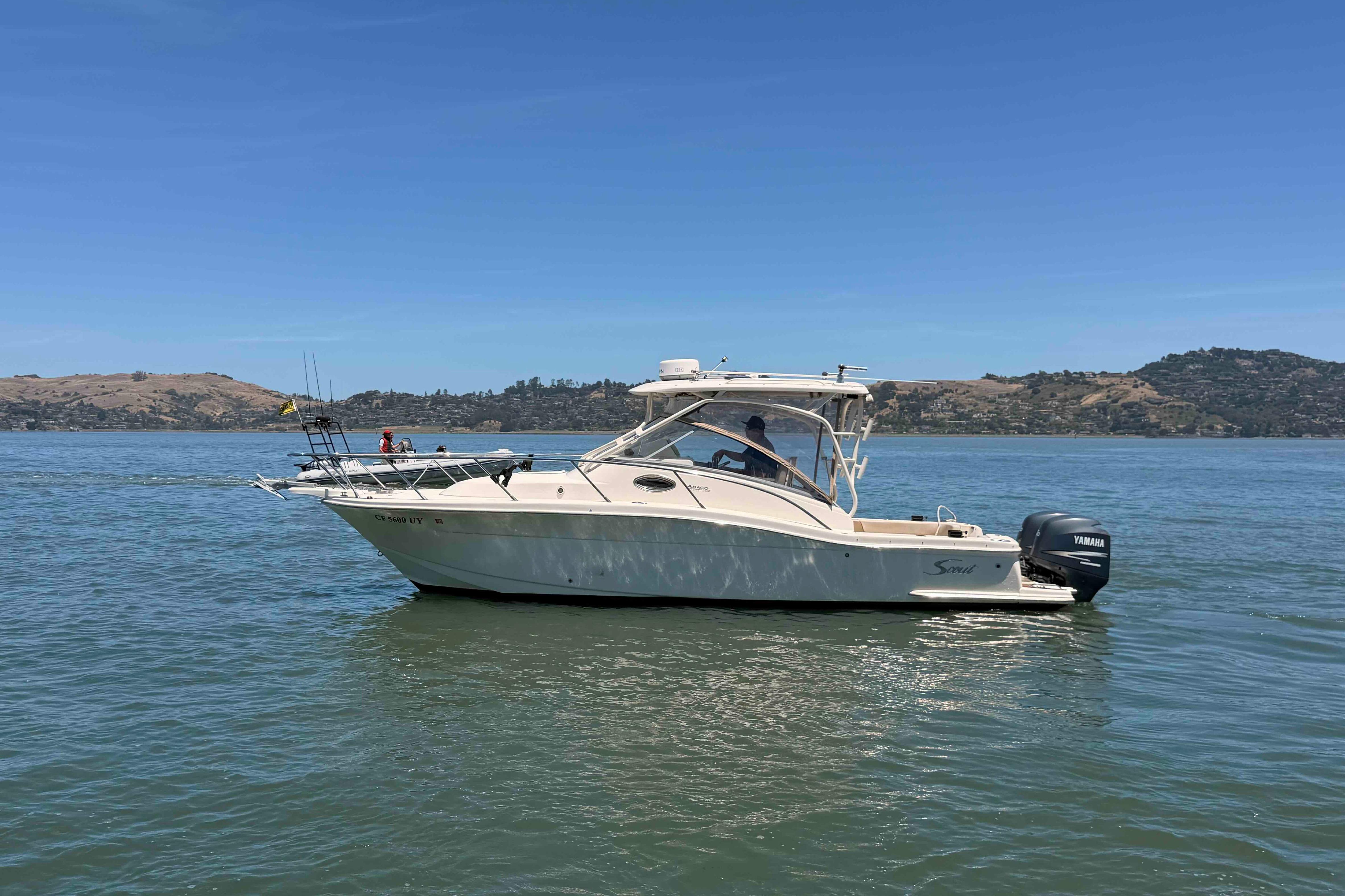 2007 Scout 262 Abaco boat on calm water with scenic hills in the background.