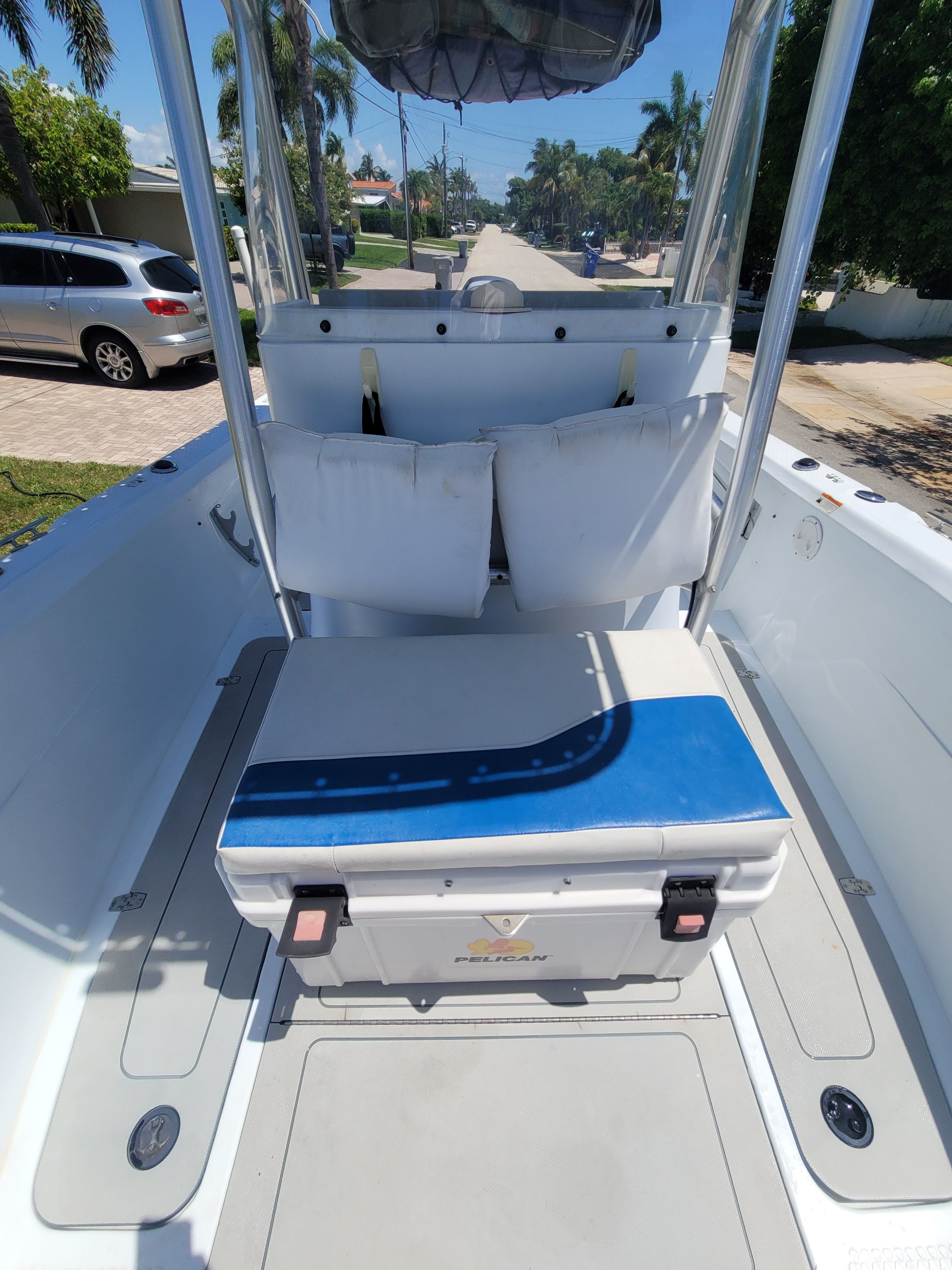 A 2005 Triumph VS boat with seating and cushions, parked in a residential area.