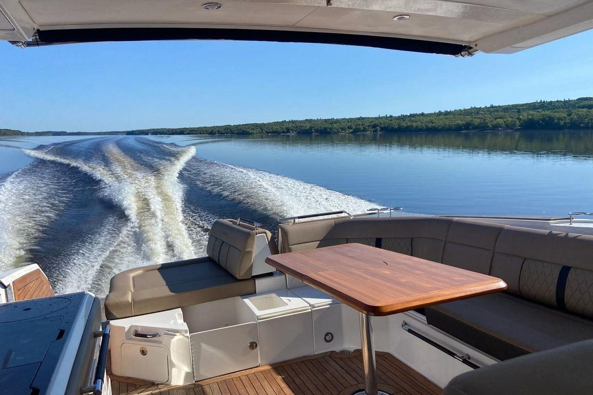 2018 Sea Ray SLX 400 cruising on a serene lake with wake trails.