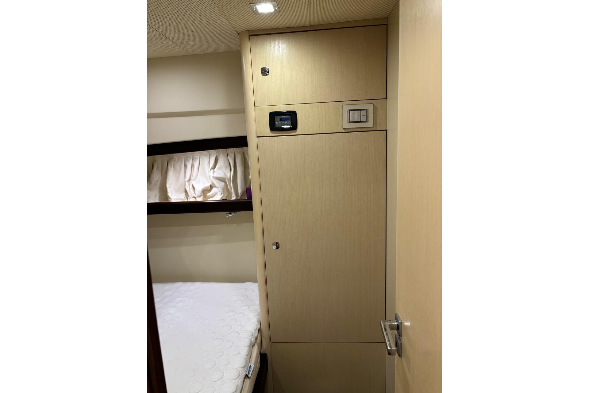 Interior cabin of 2010 Portofino 47 Fly yacht with bed and storage.