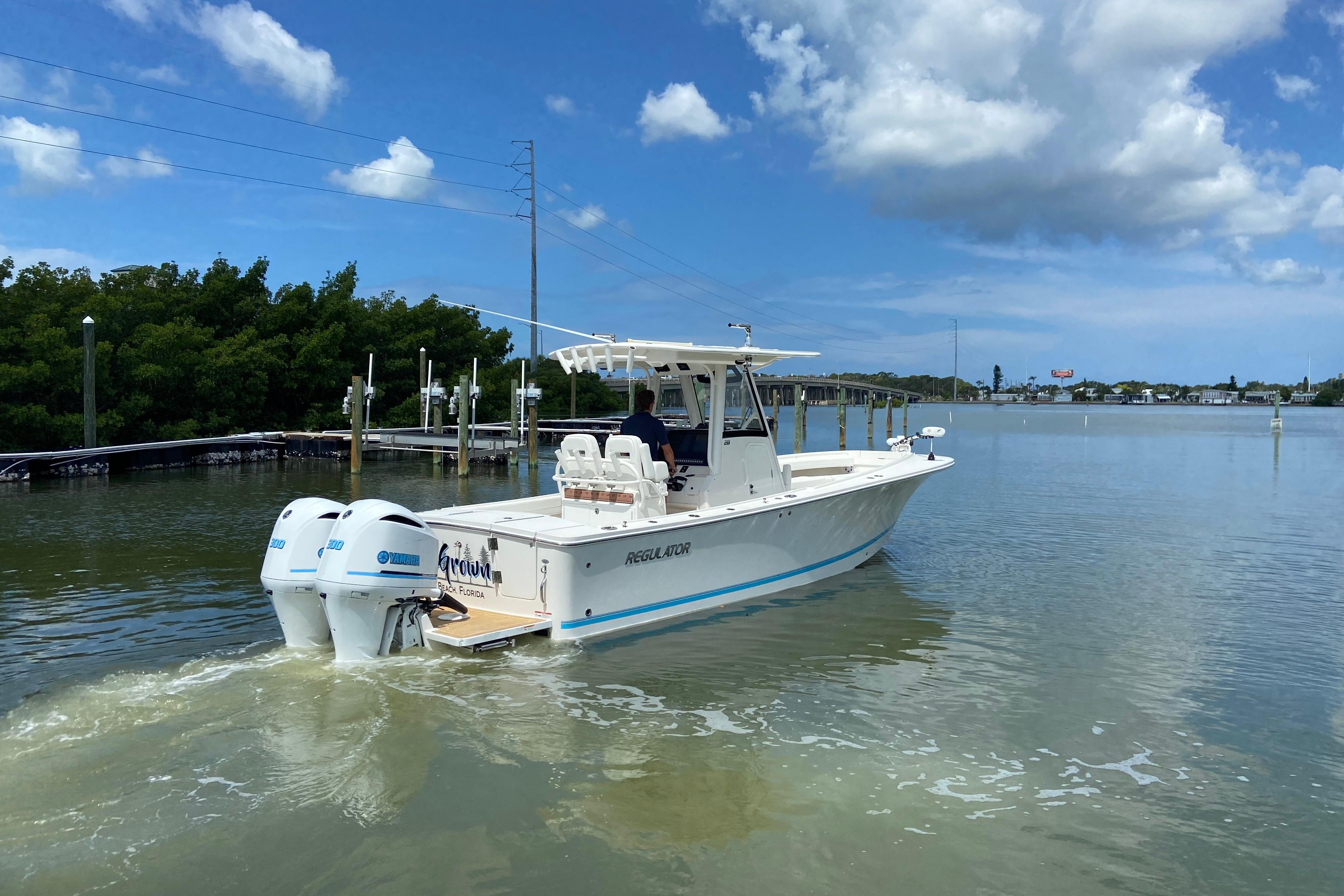 2021 Regulator 28 boat cruising on calm waters under a clear blue sky.